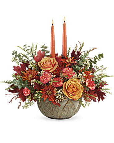 Artisanal Autumn Centerpiece - Warm their hearts and brighten their table with this lush fall rose centerpiece, arranged in a hand-glazed, oven-to-table stoneware serving bowl they'll enjoy for many years to come! Light orange roses, orange miniature carnations, and bronze cushion spray chrysanthemums are accented with white waxflower, spiral eucalyptus, grevillea, seeded eucalyptus, brown transparent oak leaves, and two peach candles. Delivered in Teleflora's Artisanal Autumn Bowl. Orientation: All-Around  VASE: FDA-approved to safely serve and store food, this gorgeous hand-glazed stoneware serving dish is oven, microwave and dishwasher-safe! Size: 15.5"h x 17" w