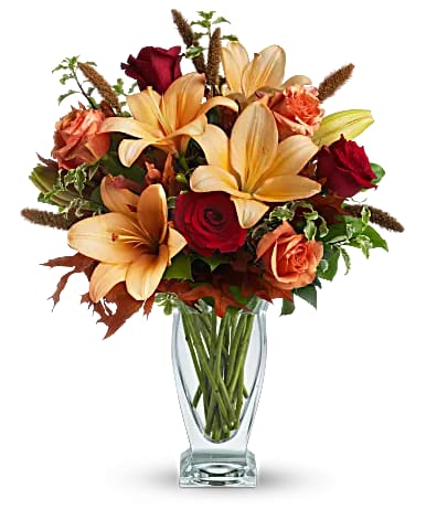 Fall Fantasia - Roses, lilies and oak leaves create a fantasy of fall flowers. Send this tall, elegant arrangement to wish someone a happy autumn or joyous Thanksgiving. The warm color palette and Couture Vase make a stylish seasonal statement.