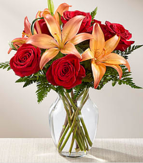 Fall Fire - Rich red roses are paired with orange Asiatic Lilies to create a harvest display your special recipient will love. Presented in a clear glass vase , this bouquet glows with gratitude and fall's best hues to create a wonderful thank you, thinking of you, or happy Thanksgiving Day gift.