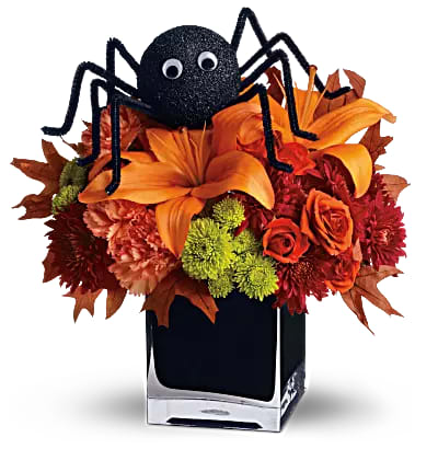 Spooky Sweet - A googly-eyed spider sits atop a beautiful bouquet of orange roses, orange asiatic lilies, orange carnations, green button mums and red cushion mums.