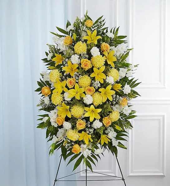 Standing floral spray with yellow lilies, roses, and white flowers