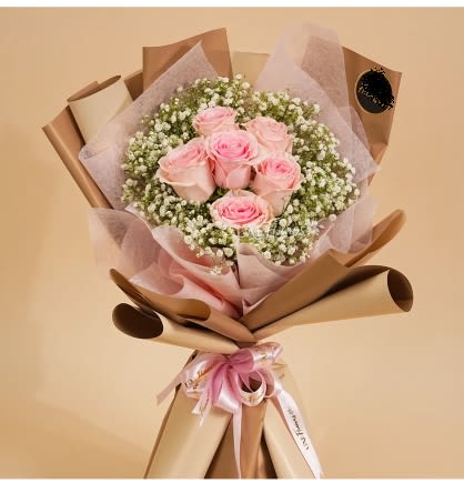 CHARMING PINK ROSE WRAPPING BOUQUET  - The Charming Pink Rose Bouquet showcases 6 fresh pink roses paired with delicate baby’s breath, elegantly wrapped in stylish brown paper. This graceful bouquet embodies timeless beauty and sophistication, making it a perfect gift for expressing heartfelt sentiments on special occasions. Its classic charm never fails to impress.!Standard: 6 Roses. Deluxe:12 Roses. Premium: 24 Roses. 