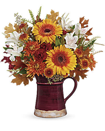 Blooming Fall Bouquet - Bring the beauty of the outdoors in with this wildly wondrous bouquet of blooms, featuring the classic hues of autumn arranged in a hand-glazed, food-safe ceramic pitcher for years of enjoyment. This blooming bouquet includes orange gerberas, white alstroemeria, maroon miniature carnations, bronze button spray chrysanthemums, bronze cushion spray chrysanthemums, grevillea, seeded eucalyptus, and autumn transparent oak leaves. Delivered in Teleflora's Fields of Fall Pitcher. Orientation: All-Around  VASE: This beautiful fall pitcher is both charming and useful, guaranteed to be a treasured décor piece for years to come. FDA-approved to safely serve and store food sIZE: 14"H X 15"w
