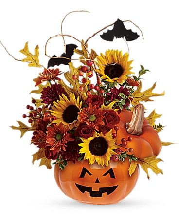 Tricks and Treats Bouquet - This is one impressive boo-quet! Red spray roses and bright yellow sunflowers are accented by curly willow and festive black bats. Situated inside the ceramic Trick &amp; Treat Pumpkin and adorned by a scary jack-o-lantern face, this arrangement is fang-tastic!