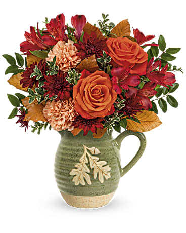 Charming Acorn Bouquet - Charming Acorn Bouquet embraces autumn. This charming glazed stoneware pitcher is bursting with fall flowers like roses, carnations, alstroemeria, and chrysanthemums! The embossed design vase is food- safe for years of pouring pleasure. The arrangement for fall is filled with orange roses, peach carnations, red alstroemeria, bronze cushion spray chrysanthemums and brown copper beech are arranged with huckleberry and oregonia. Delivered in Teleflora's Charming Acorn Pitcher. Approximately 15" W x 15" H