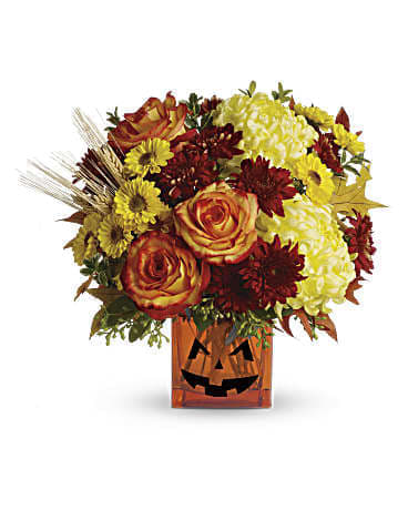 Halloween Glow - This bouquet will get you in the Halloween spirit. Yellow chrysanthemums and festive orange roses are accented by eucalyptus and autumn oak leaves. Delivered in an orange cube vase with a jack-o-lantern face, it's the perfect Halloween costume -for your table! Yellow cushion spray chrysanthemums, bi-color orange roses, rust cushion spray chrysanthemums, yellow disbud chrysanthemums, yellow viking spray chrysanthemums are accented by oregonia, eucalyptus and autumn oak leaves for a lovely fall melody. Delivered in an orange cube vase. Orientation: All-Around