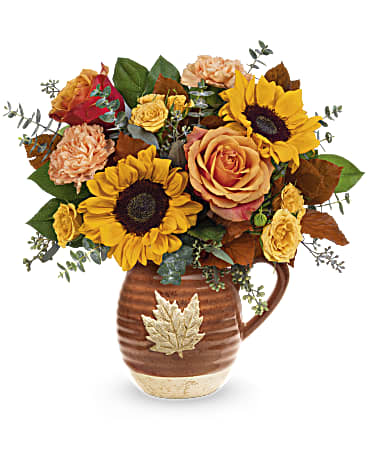 Wild Harvest Bouquet - Warm as the autumnal sun, this joyful sunflower bouquet is perfectly presented in a glazed, food-safe ceramic pitcher that's adorned with a charming maple leaf. This fall floral bouquet features orange roses, yellow spray roses, peach carnations, yellow sunflowers, brown copper beech, seeded eucalyptus, spiral eucalyptus and lemon leaf. The Wild Harvest Bouquet is delivered in Teleflora's Cascading Blooms Pitcher. Approximately 13 1/4" W x 13 1/2" H