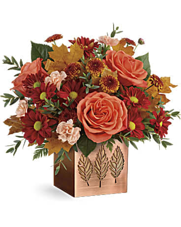 Copper Petals Bouquet - Capture the magic of fall with this seasonal rose bouquet, presented in a shimmering copper-plated cube with leaf-punched motif. Later, add a votive candle and let its autumnal style shine! Orange roses, peach miniature carnations, bronze daisy spray chrysanthemums, bronze button spray chrysanthemums, parvifolia eucalyptus, leatherleaf fern are accented with yellow preserved oak leaves. Delivered in Teleflora's Copper Petals Cube. Orientation: All-Around  VASE: This gorgeous metal cube is finished with a copper-painted glaze with a punched leaf design, perfect filled with fall blooms or as a candle holder! 