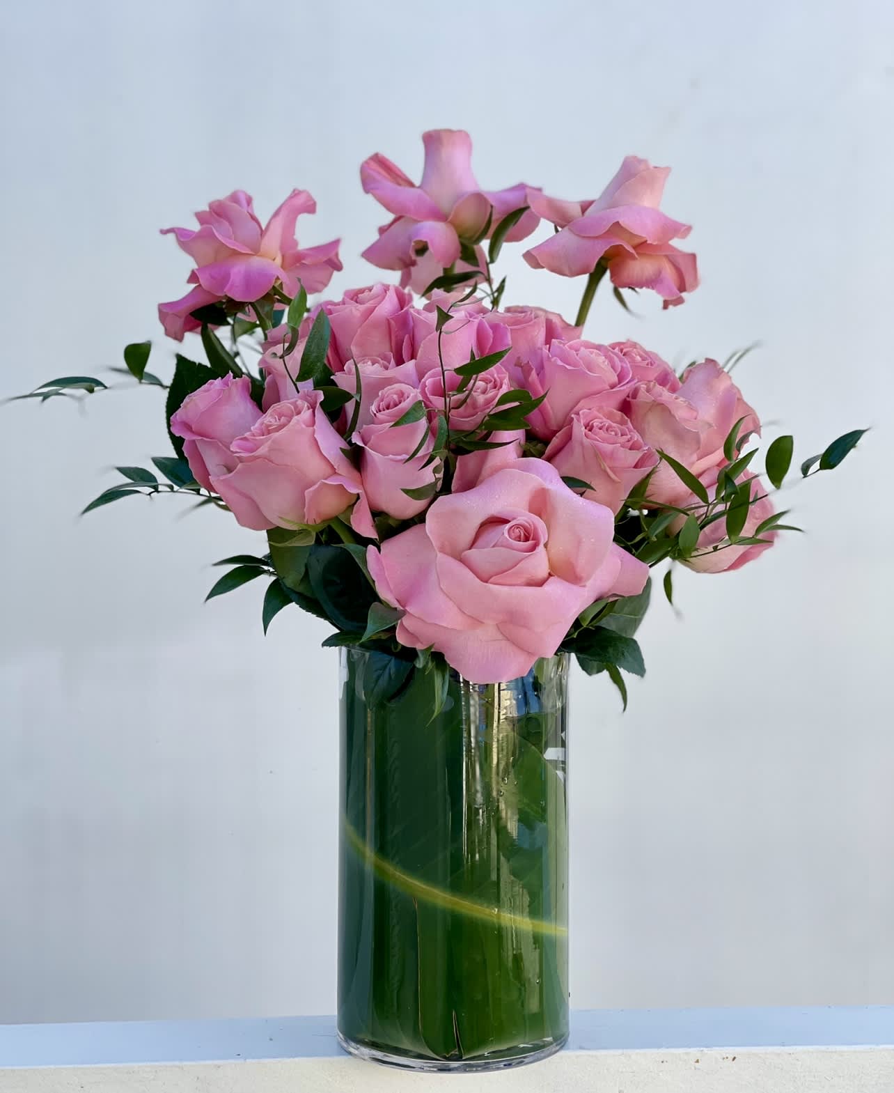 Pink roses arranged in a clear glass vase