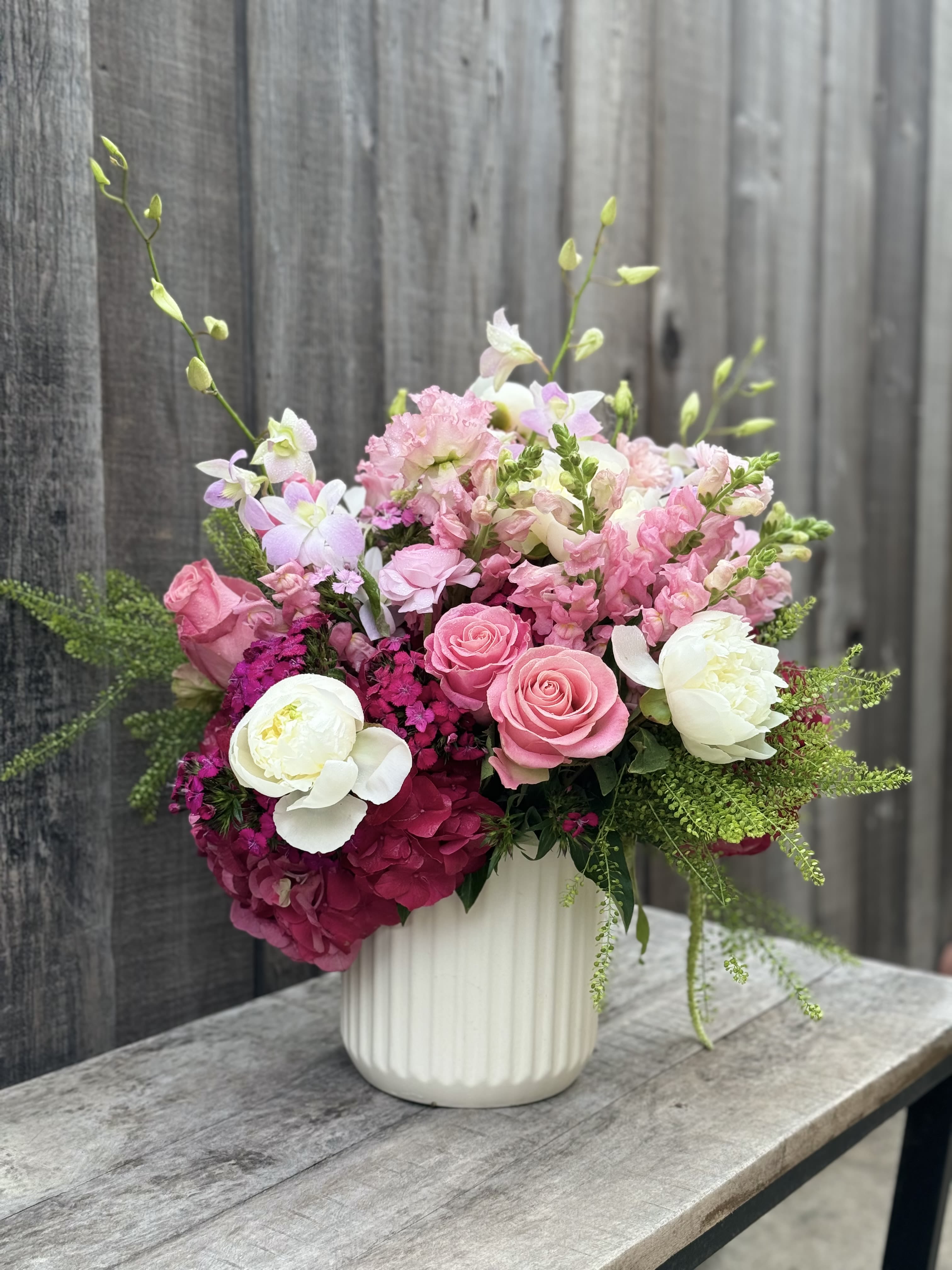 Pink and white floral arrangement in a white vase