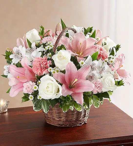 Peace &amp; Blessings   Pink &amp; White basket  - Representing care, compassion and love - pink blooms can offer solace in times of sorrow. Artistically designed inside a keepsake willow basket, our arrangement in soothing pink hues is a touching way to offer your sincerest blessings.  white roses, alstroemeria and monte casino and pink Asiatic lilies, carnations and mini carnations; accented with fresh greenery