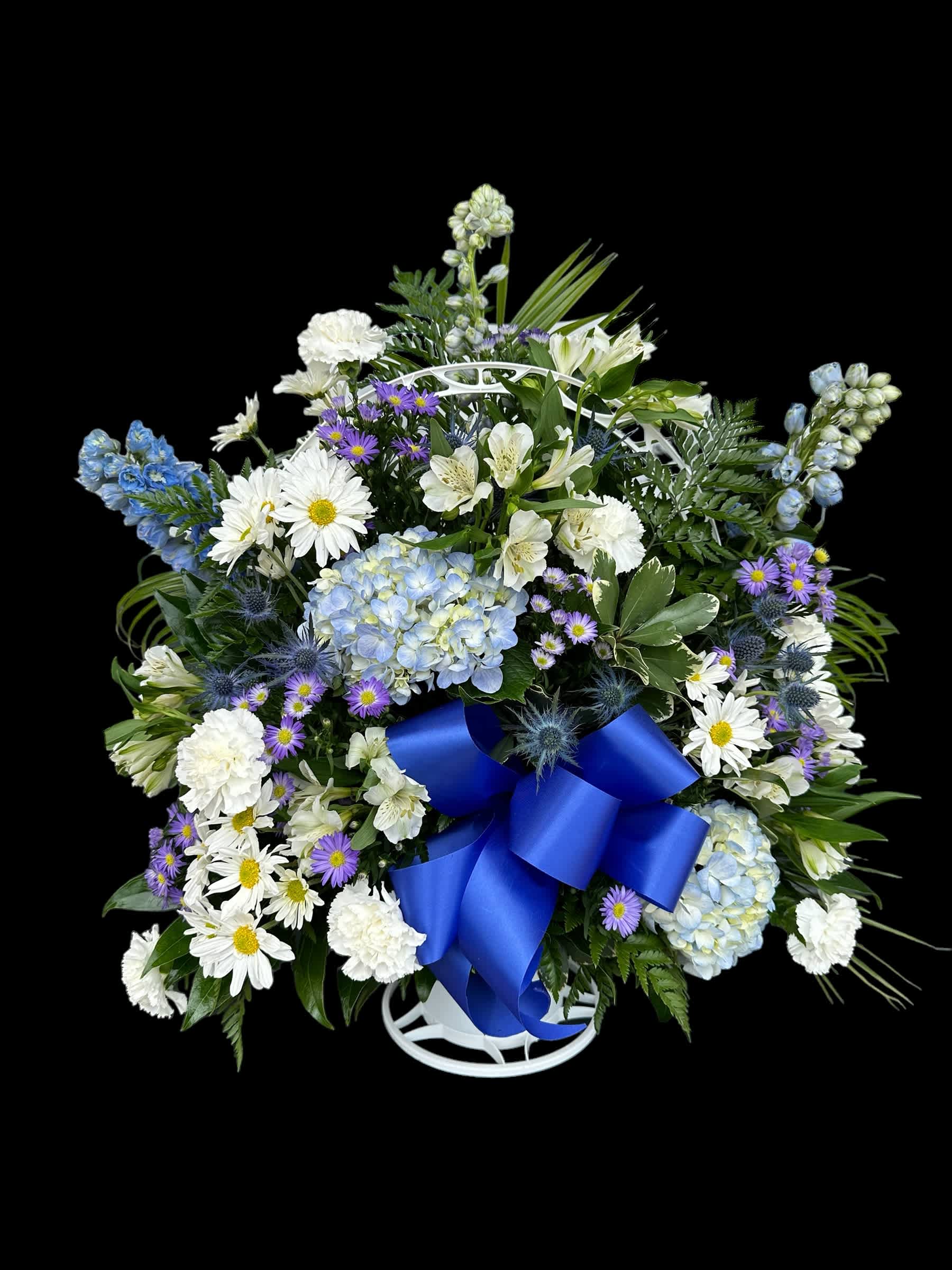 Blue and white floral standing spray with a large blue ribbon