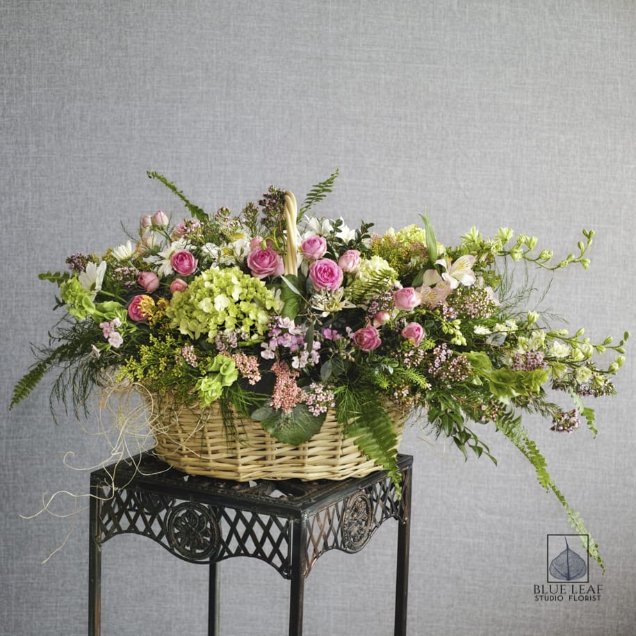 Large basket arrangement with pink roses and mixed blooms