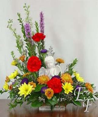Colorful floral arrangement with a white angel figurine