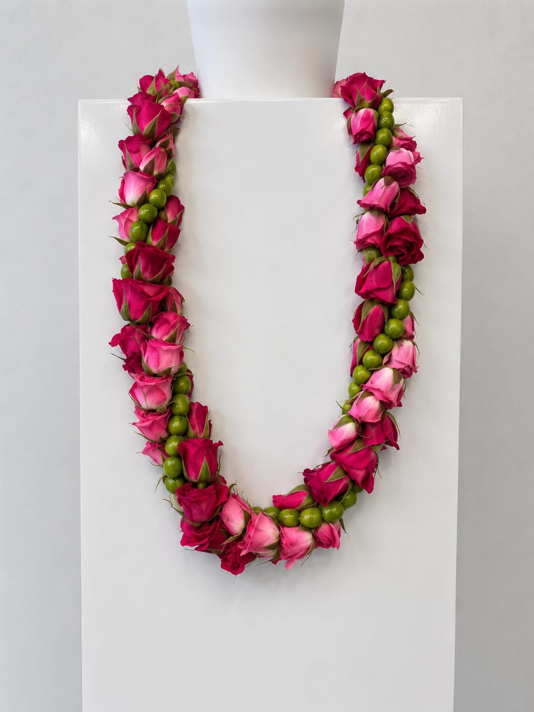 Rose and Berry Lei - Celebrate a special milestone with a beautifully crafted rose and berry lei, designed with soft elegance and fresh, natural texture. This handcrafted lei features delicate spray roses in shades of pink or white, accented with vibrant green hypericum berries for a unique and modern floral look.  Each lei is hand-strung in-house, ensuring quality, freshness, and attention to detail in every piece. The combination of petite spray roses and textured berries creates a balanced, full design that feels both romantic and contemporary. The soft blush or crisp white tones paired with fresh green accents make this lei a versatile choice that complements any graduation attire.  Perfect for graduations, celebrations, and milestone events, this rose and berry lei symbolizes love, pride, and new beginnings. Its lightweight and flexible design allows for a comfortable fit while maintaining a polished, elegant appearance throughout the day.  Whether you’re celebrating a high school or college graduate, this lei offers a thoughtful and stylish alternative to traditional designs. It photographs beautifully and adds a fresh, garden-inspired touch to any graduation look.  Order your rose and hypericum berry lei today for pickup or delivery, and honor your graduate with a handcrafted floral piece that feels both timeless and uniquely special.  Please allow at least a 1 day heads-up to create your lei.