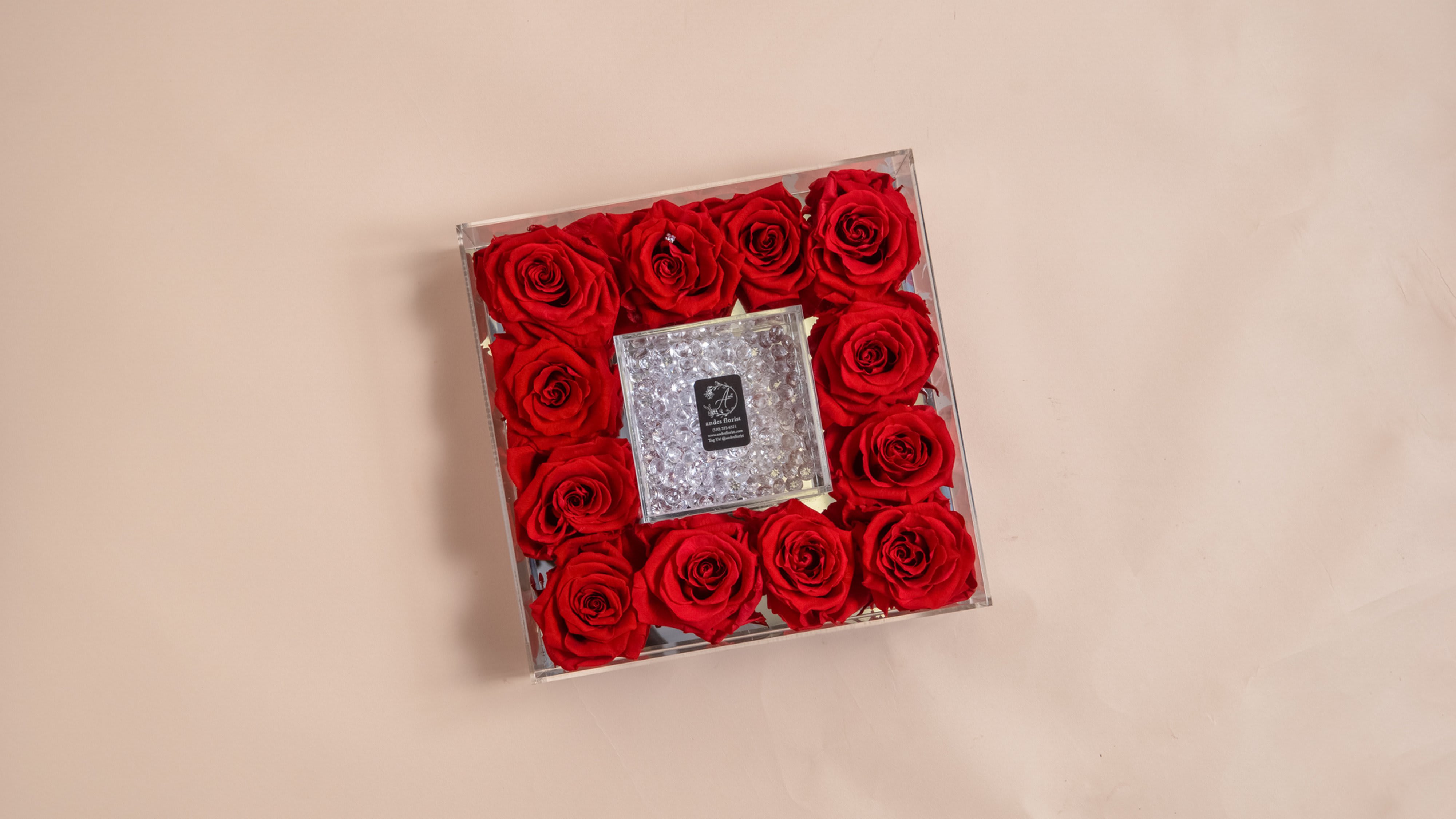 Square box of red roses with a clear jeweled center