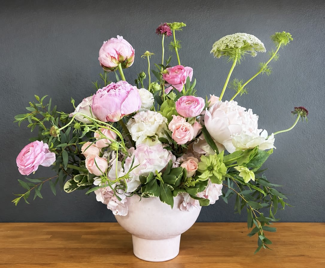 Blush Garden - A soft and sophisticated blend of peonies, ranunculus, and seasonal blooms in delicate shades of blush, cream, and green. Designed with natural texture and graceful movement. Blush Garden brings timeless beauty to any space-perfect for celebrations, thoughtful gifts, or elevated everyday moments. 