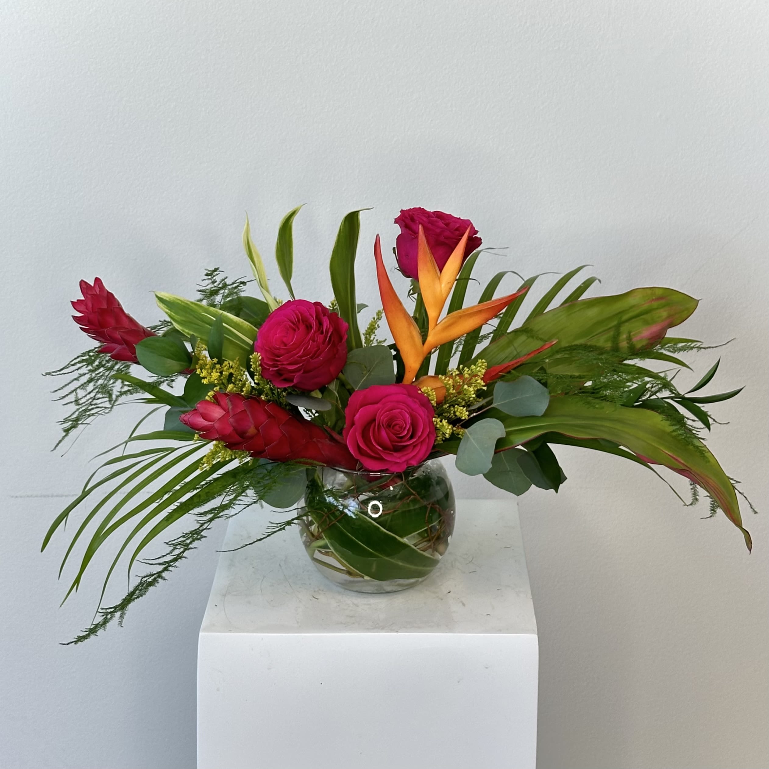 Paradise Bouquet - Bring the beauty of the tropics home with Paradise Bouquet, a bold and vibrant floral arrangement inspired by lush island landscapes and exotic blooms. This tropical bouquet features striking Birds of Paradise, vivid ginger, vibrant fuchsia roses, and lush palm leaves, creating a dramatic design filled with texture, movement, and unforgettable color. Every stem is thoughtfully selected to capture the feeling of a relaxing getaway while showcasing the natural beauty of premium tropical flowers.  The architectural shape of the Bird of Paradise makes it the focal point of the arrangement, while exotic ginger adds rich texture and bold tropical flair. Fuchsia roses introduce a romantic pop of color that beautifully complements the lush greenery of the palm leaves, creating a balanced design that feels both luxurious and contemporary.  Perfect for birthdays, congratulations, housewarming gifts, corporate events, tropical-themed celebrations, or simply brightening a home or office, Paradise Bouquet is handcrafted by our expert floral designers using fresh, premium blooms. Its eye-catching style makes it an excellent choice for anyone who loves unique floral arrangements with a modern, tropical aesthetic.  If you're searching for tropical flower delivery, Birds of Paradise arrangements, exotic flower bouquets, or a vibrant floral gift that stands out, Paradise Bouquet is the perfect choice to bring warmth, color, and a touch of paradise to any occasion.