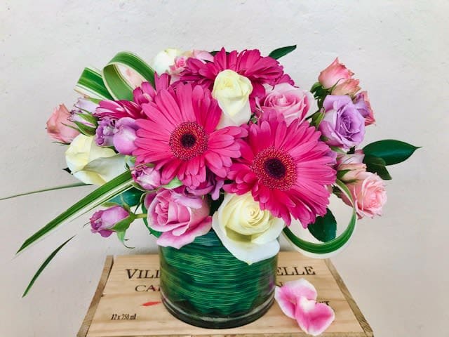 Pink and white mixed bouquet in a green glass vase