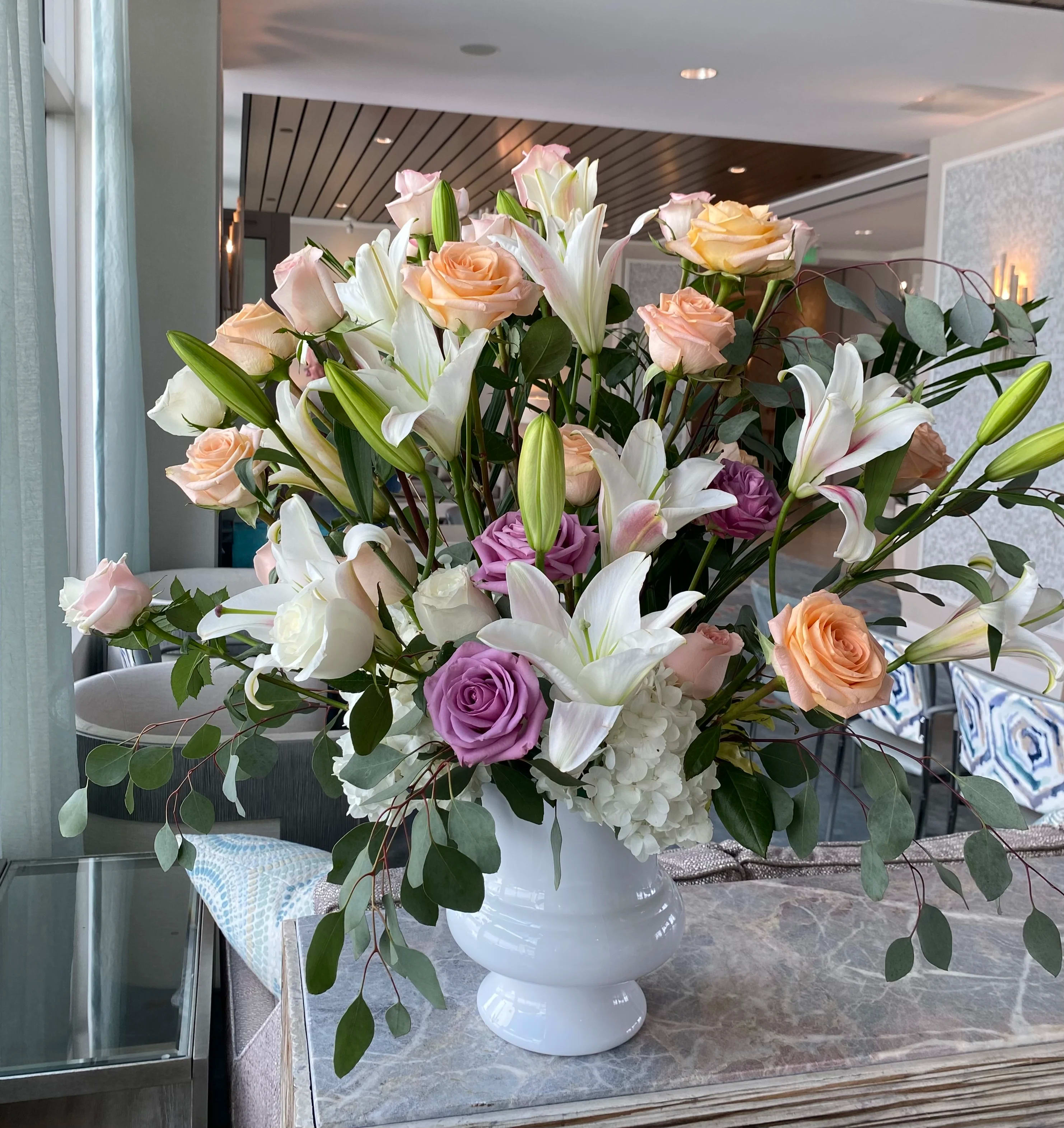 Large bouquet of roses and lilies in a white vase