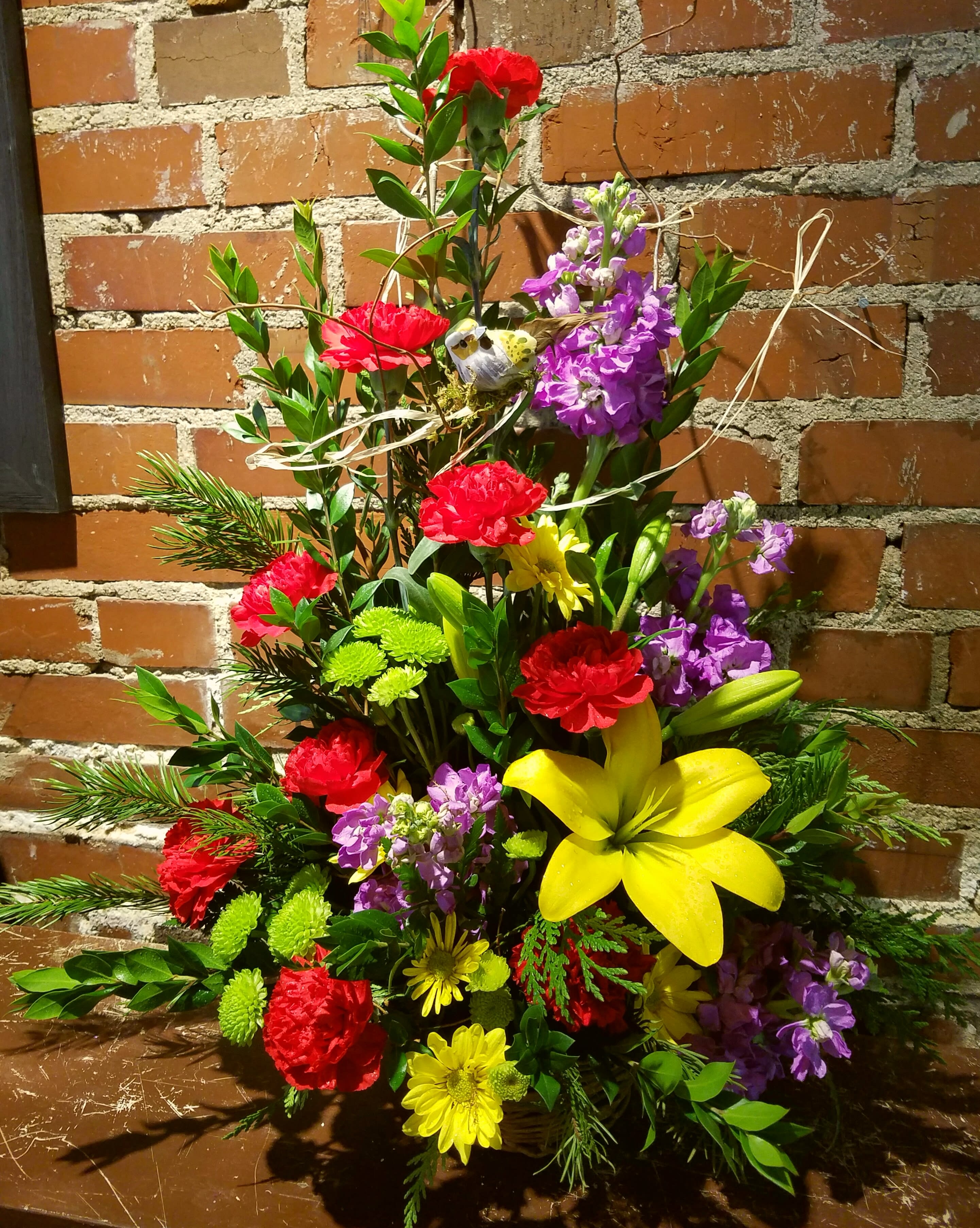 Eckert Florist's Bright and Bold Arrangement - This arrangement is created by using our finest bright and colorful flowers. Flowers featured may include asiatic lilies, stock, and carnations with lush greens. 