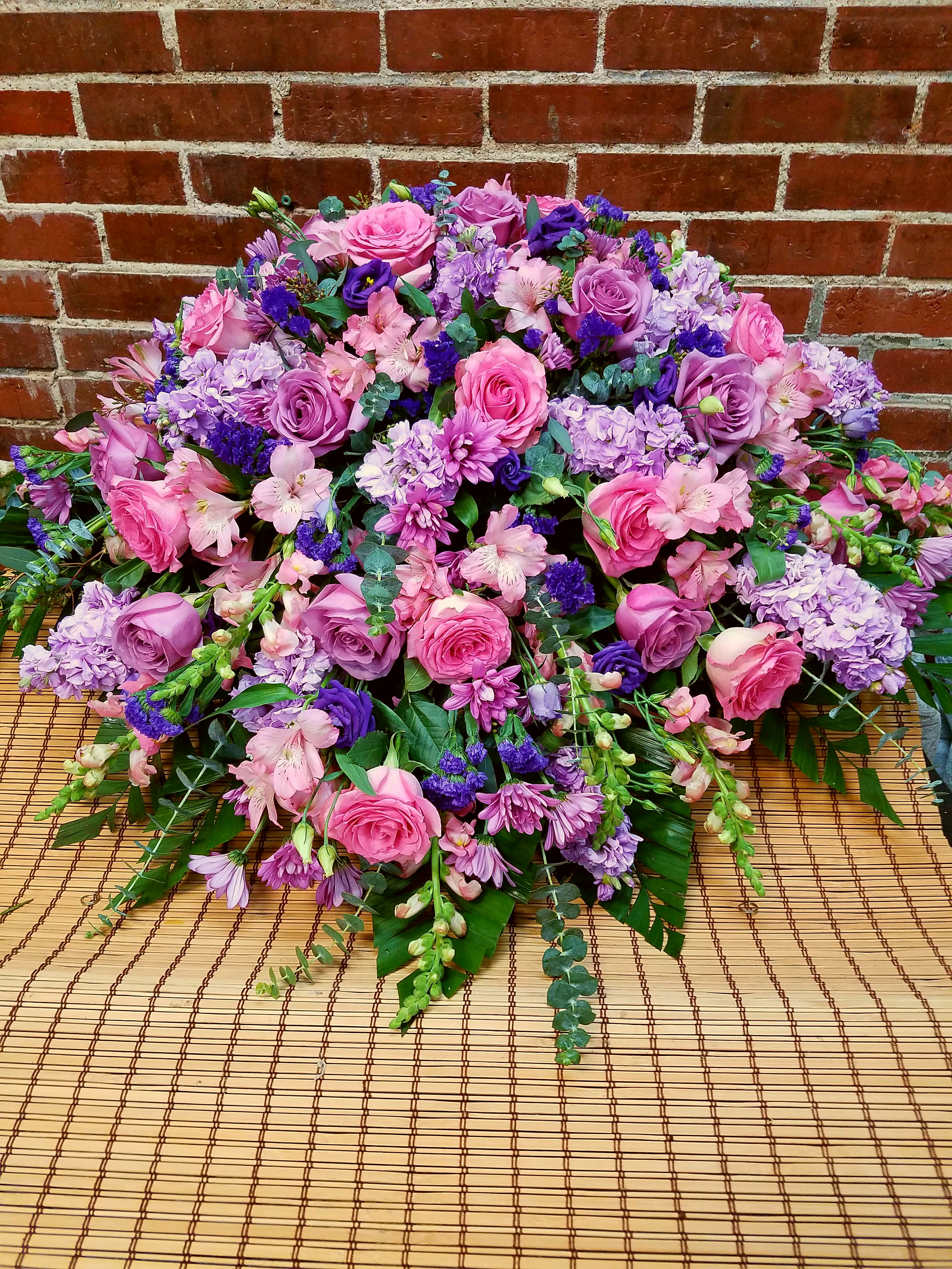 Large pink and purple floral arrangement with roses and mixed blooms
