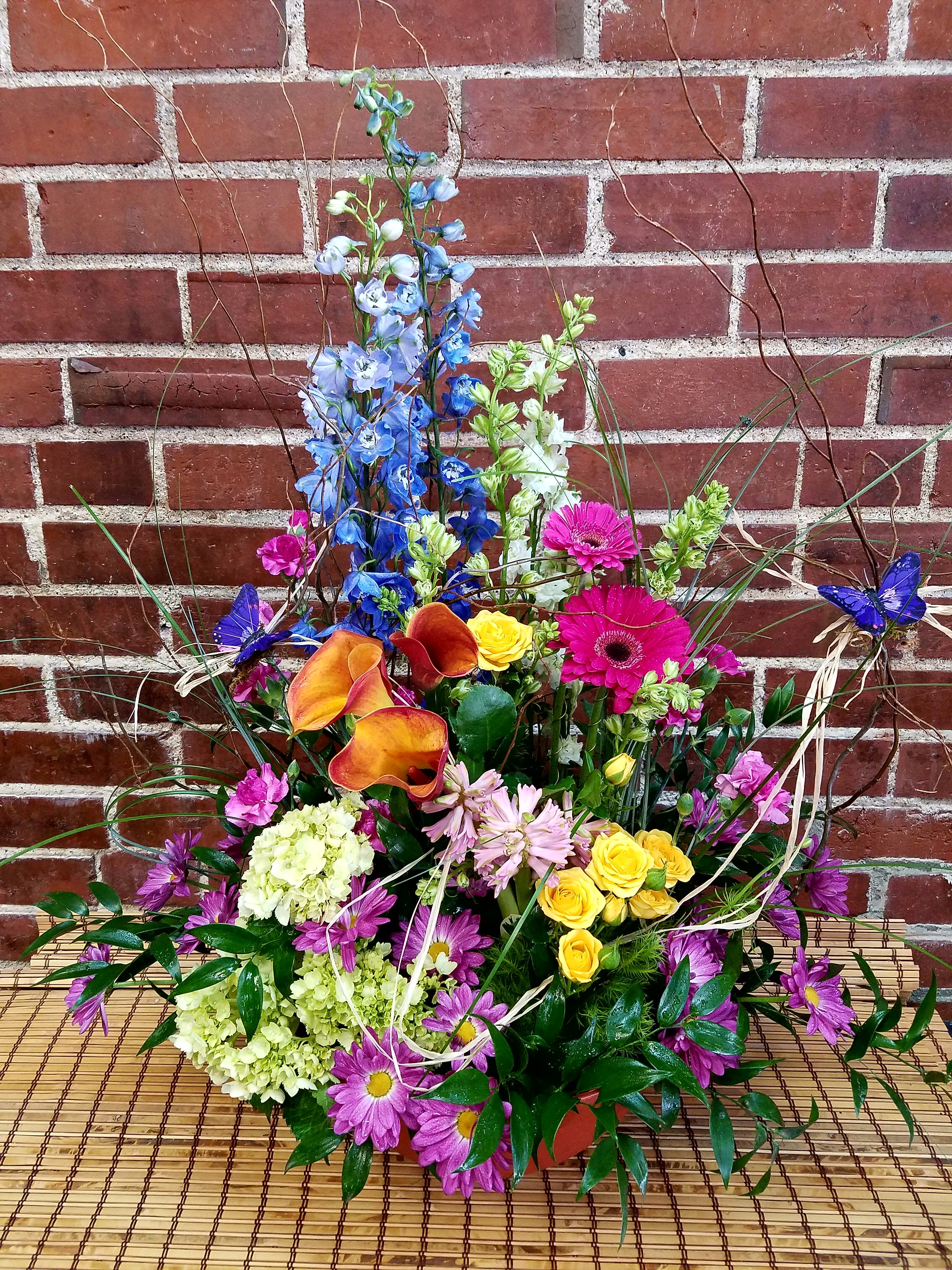 Colorful mixed flower arrangement with calla lilies, roses, and daisies
