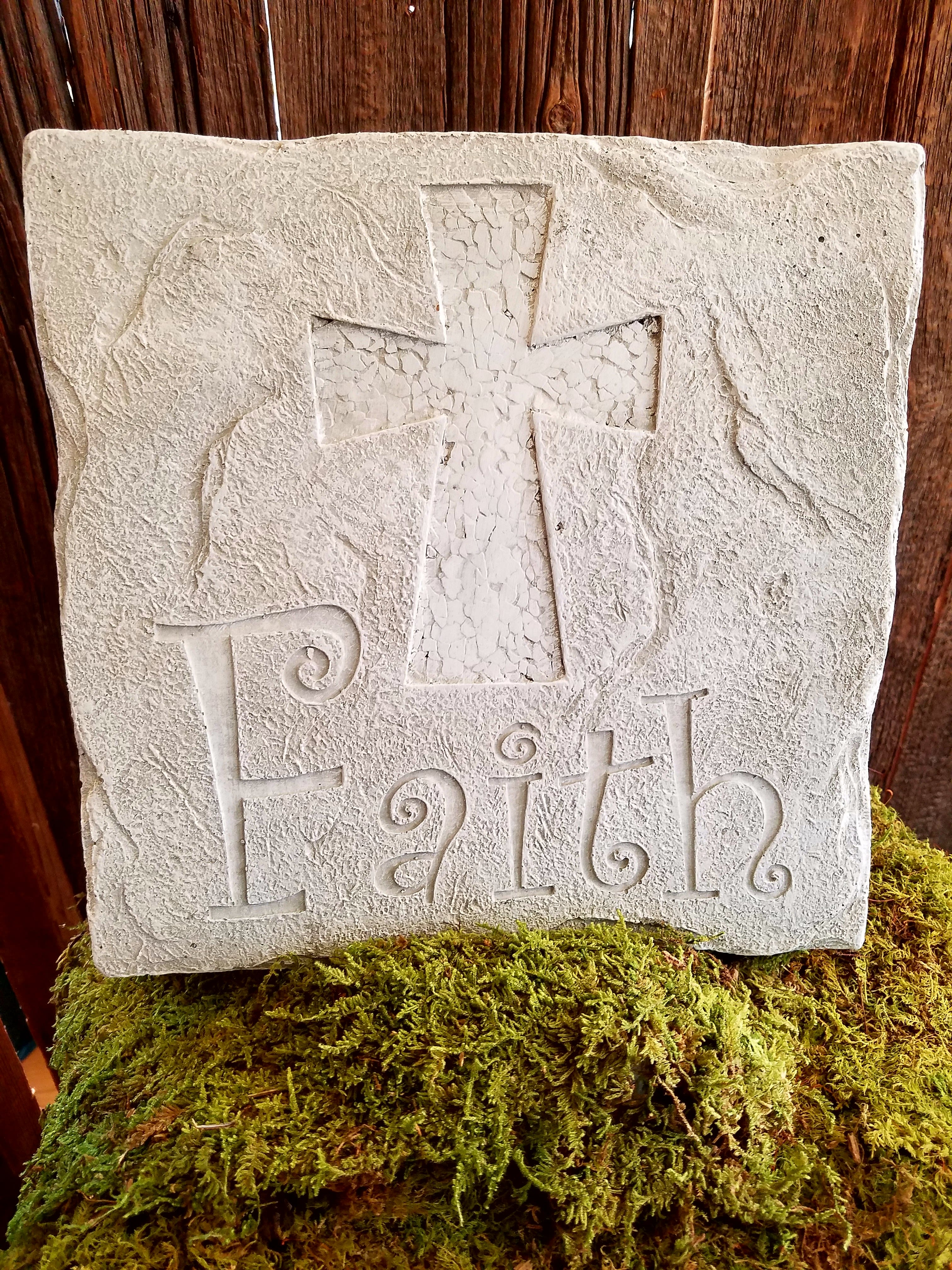 Stone plaque with a cross and the word Faith