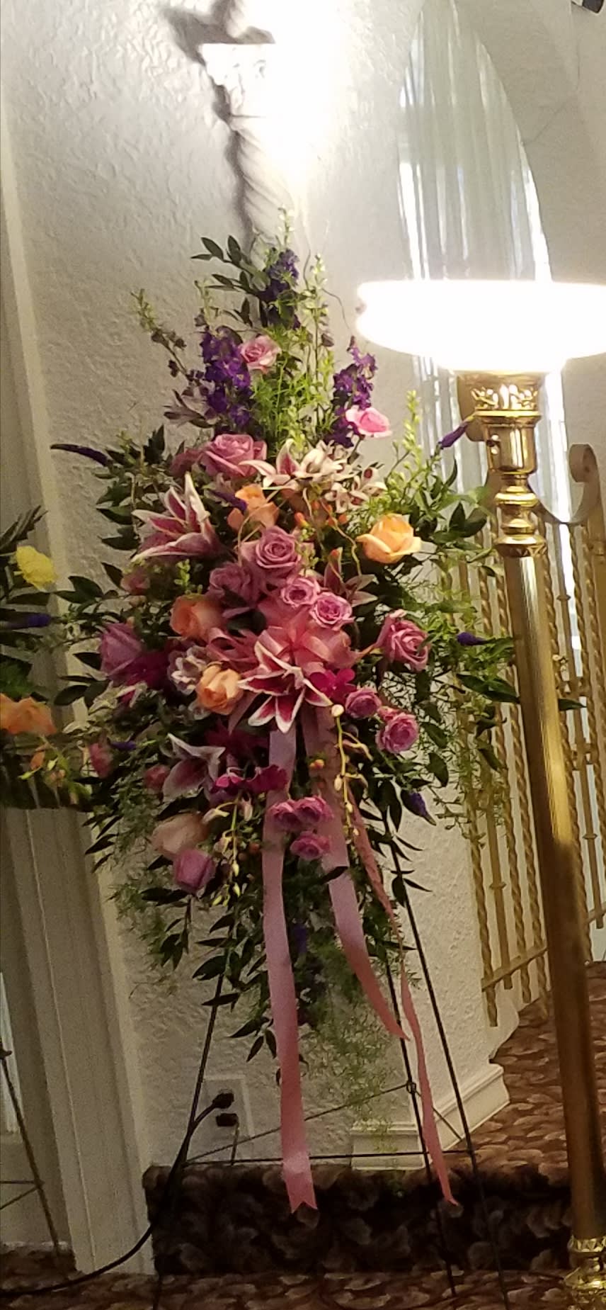 Tall floral spray with pink and purple flowers on a stand