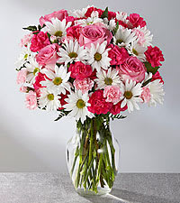 Eckert Florist's FTD Sweet Surprises Bouquet With Roses - The FTD Sweet Surprises Bouquet is an absolutely charming way to send your warmest sentiments. Spray roses, pink mini carnations, white traditional daisies and lush greens are sweetly situated in a classic clear glass vase to create a bouquet that will delight your special recipient at every turn.