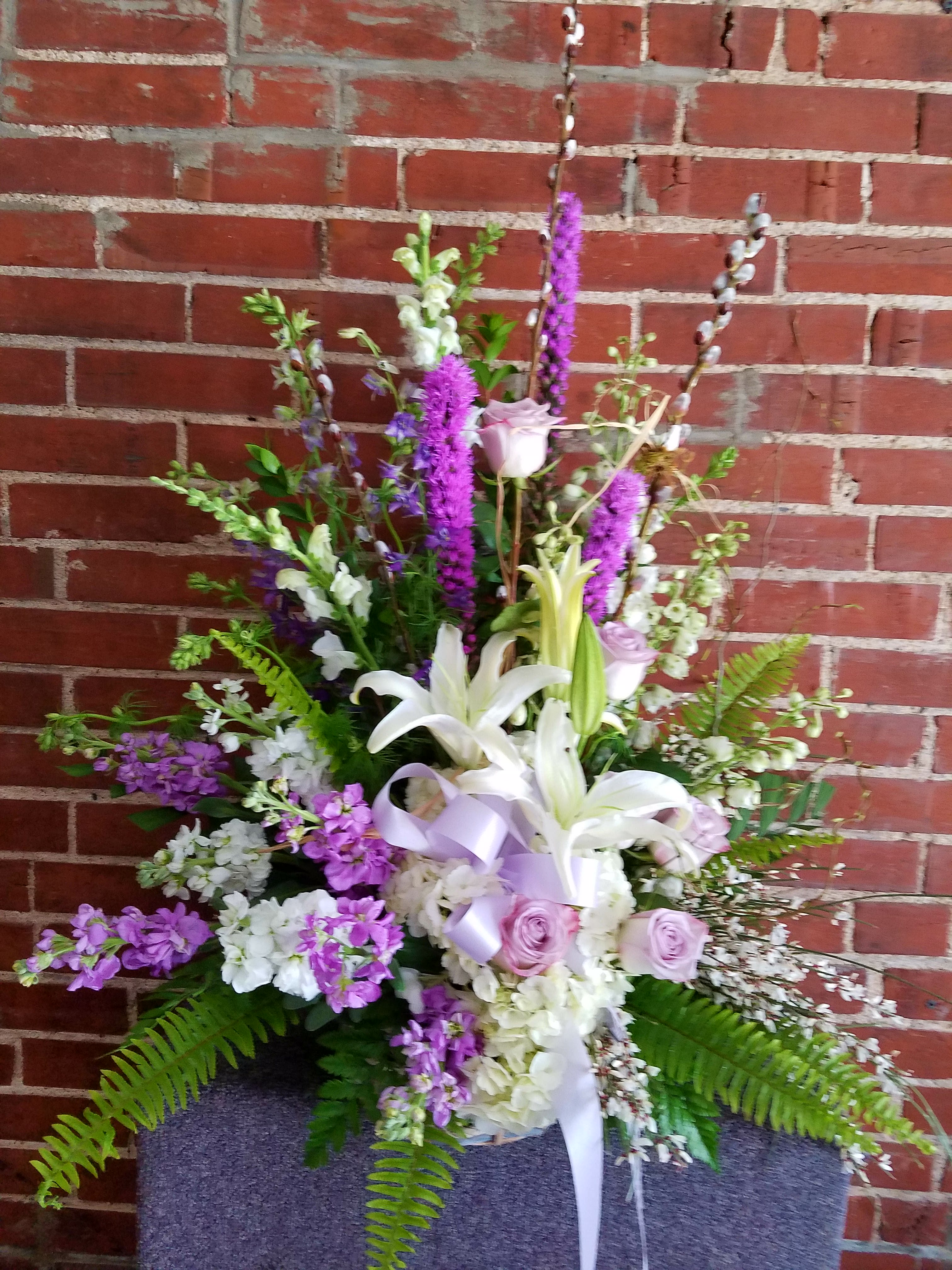 Tall floral arrangement with white lilies and lavender roses