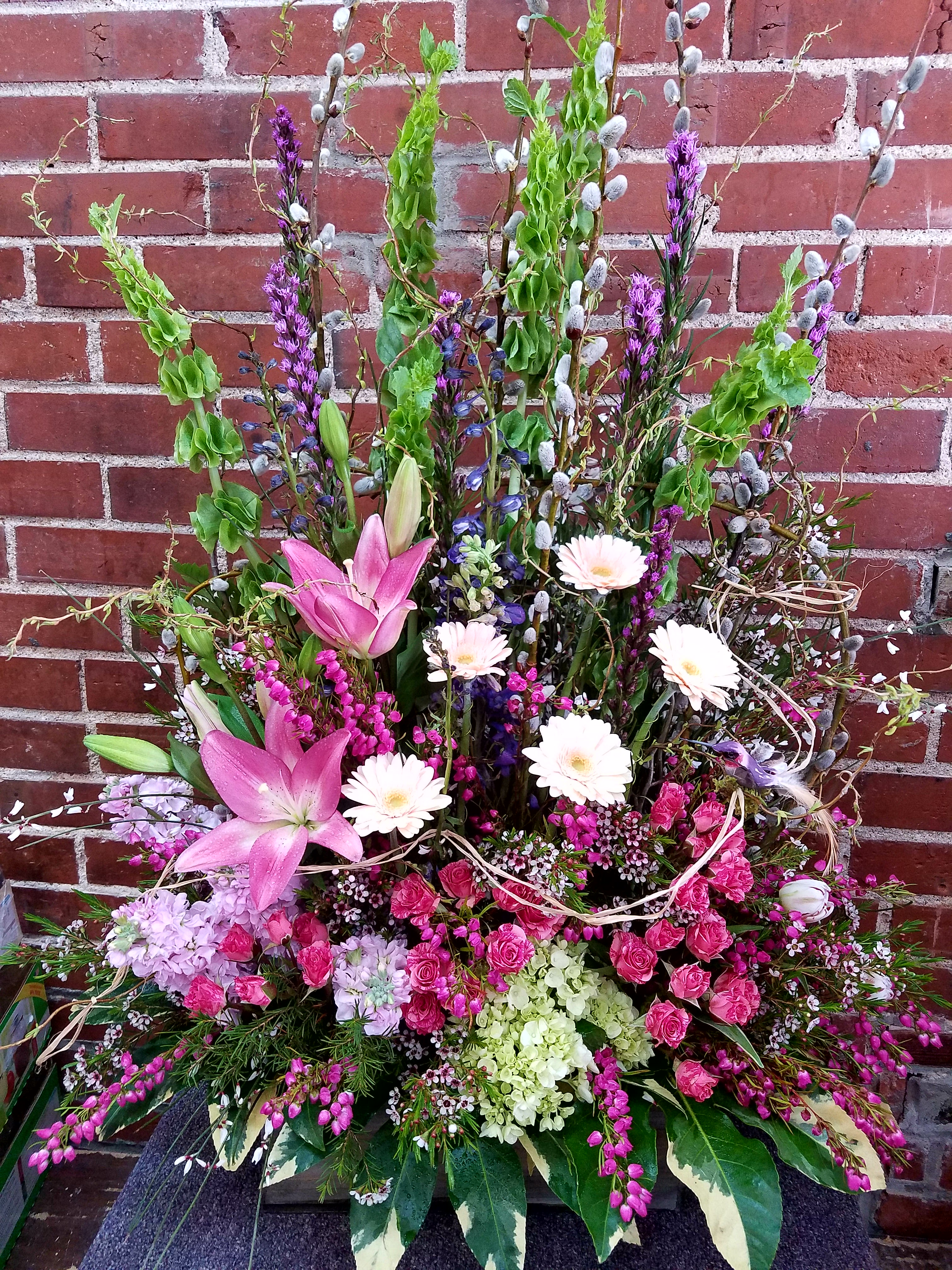 Tall mixed floral arrangement with pink lilies and white daisies