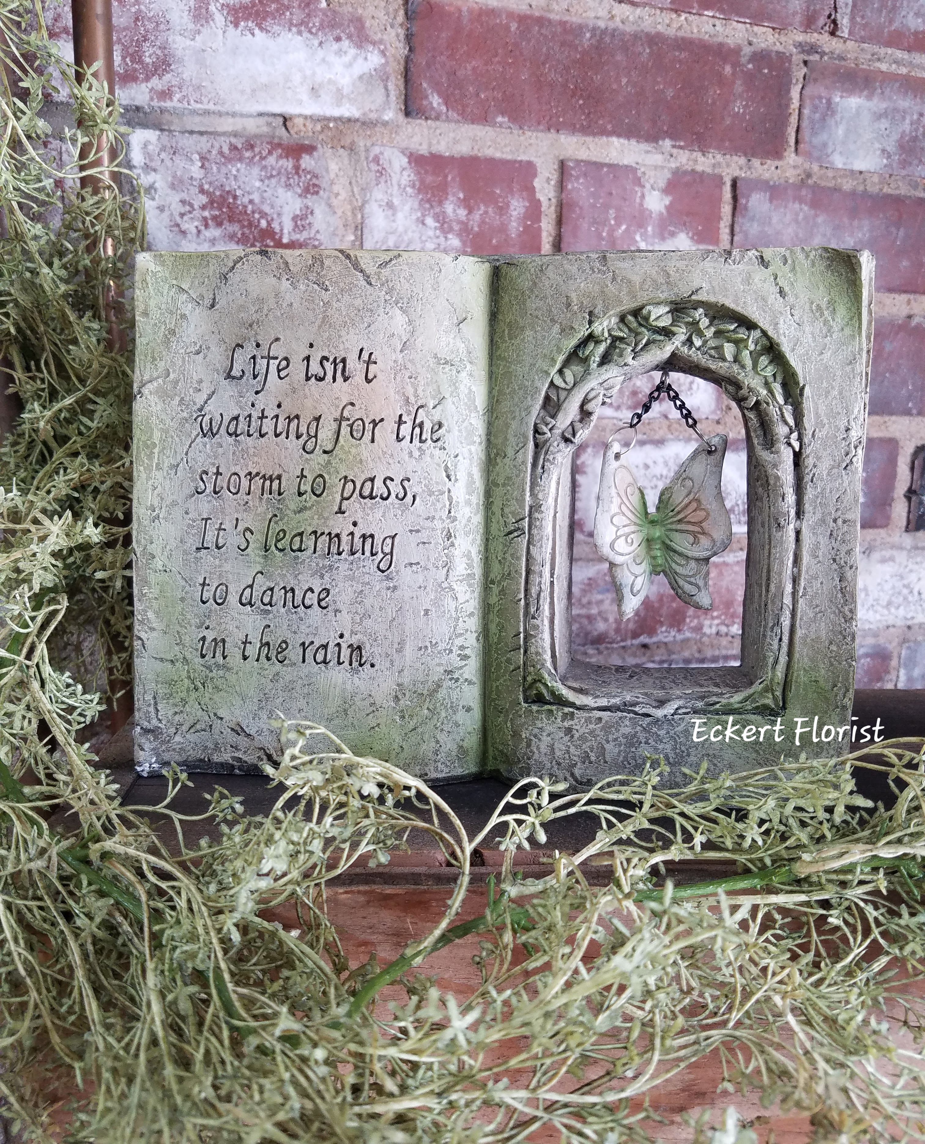 Decorative open-book plaque with a butterfly ornament and quote
