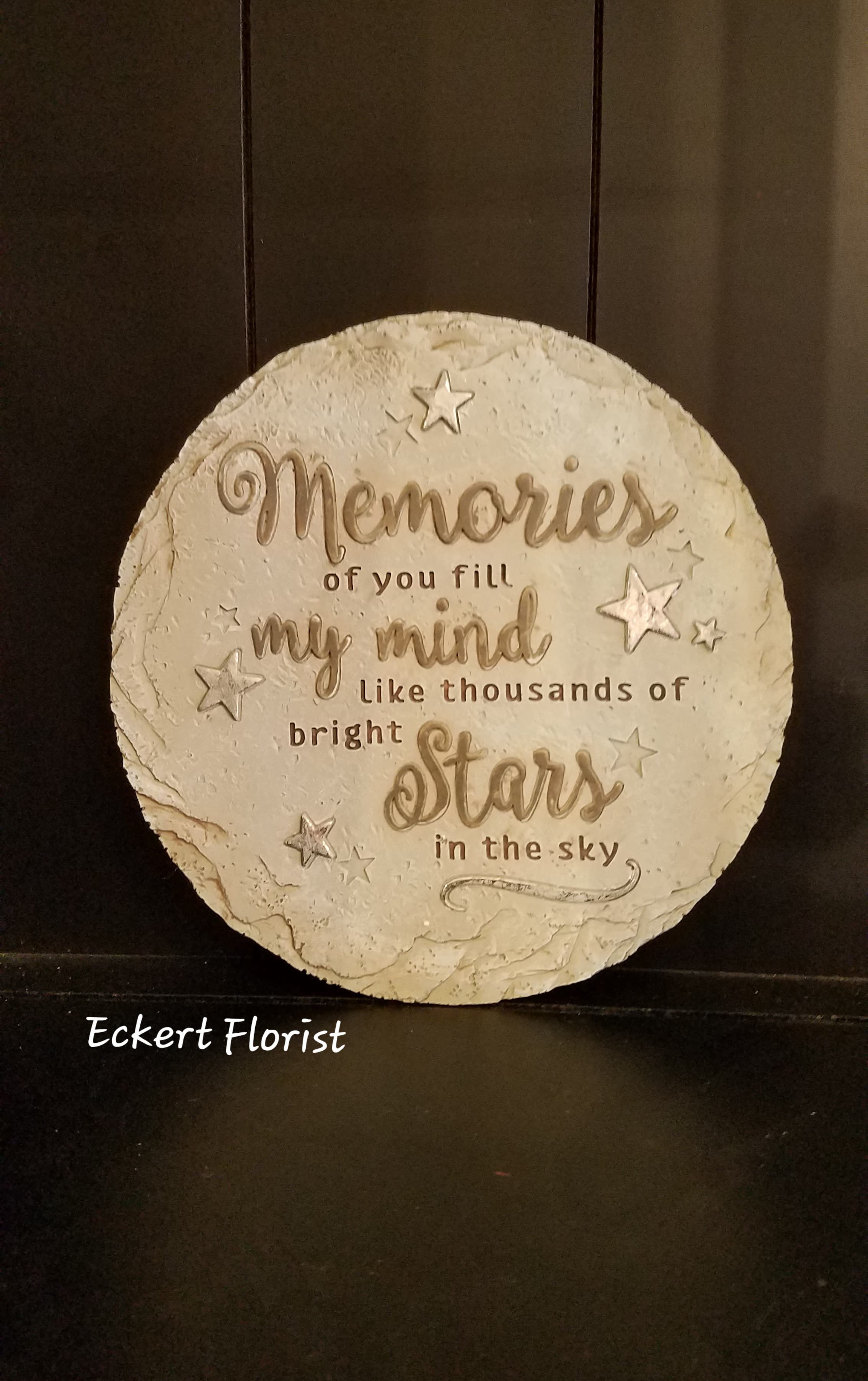 Round decorative sign with a star quote on a dark shelf