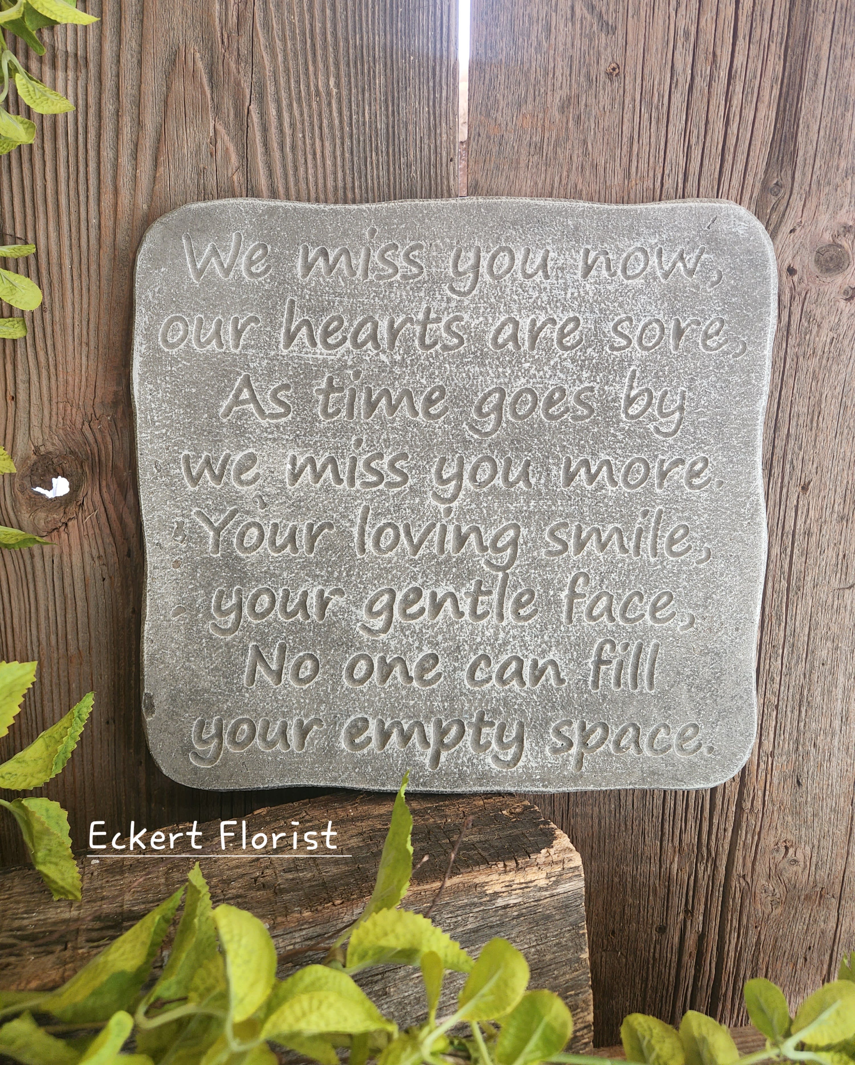 A memorial stone plaque with an engraved sympathy message.