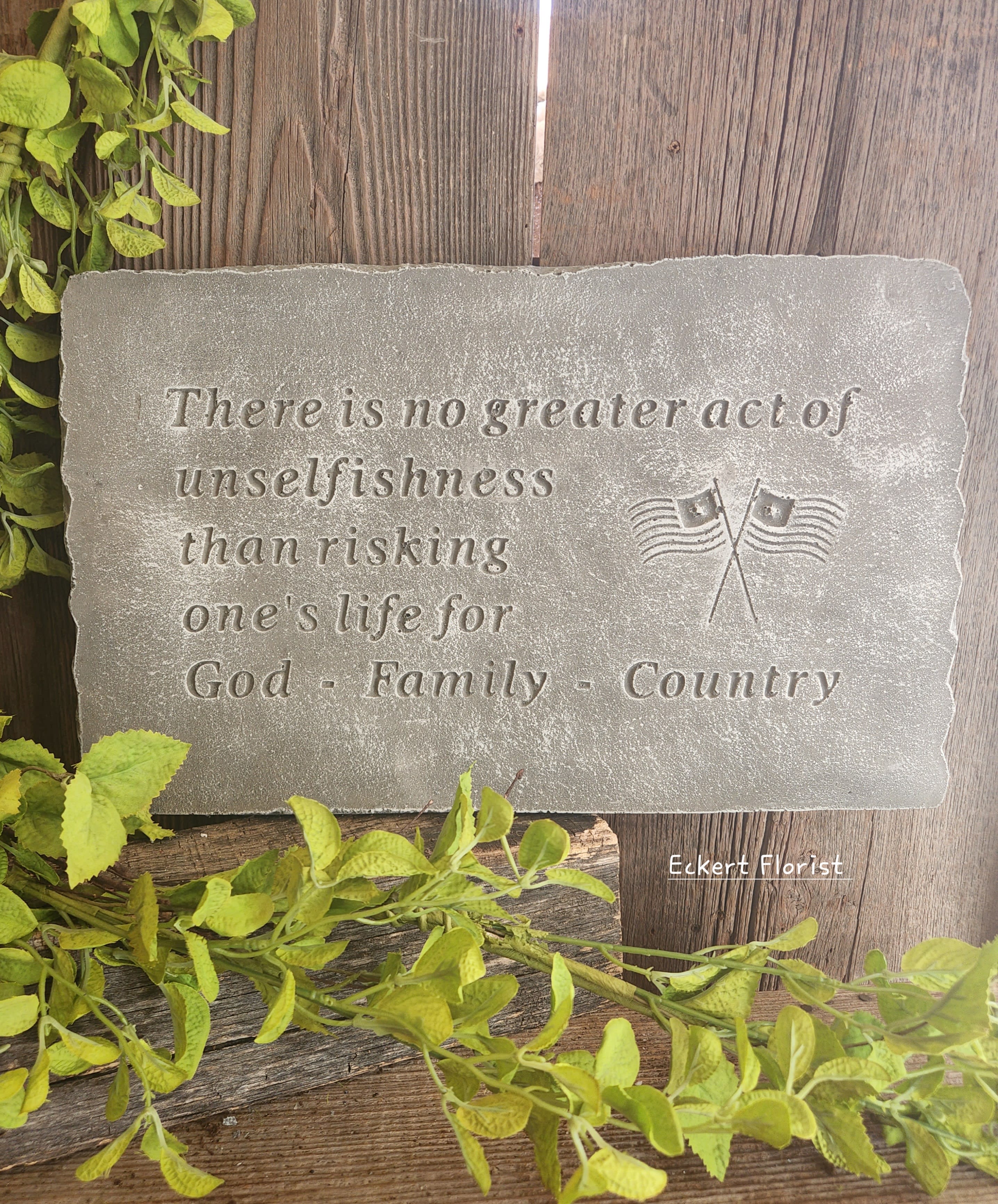 Engraved stone plaque with a patriotic quote and small flag emblem