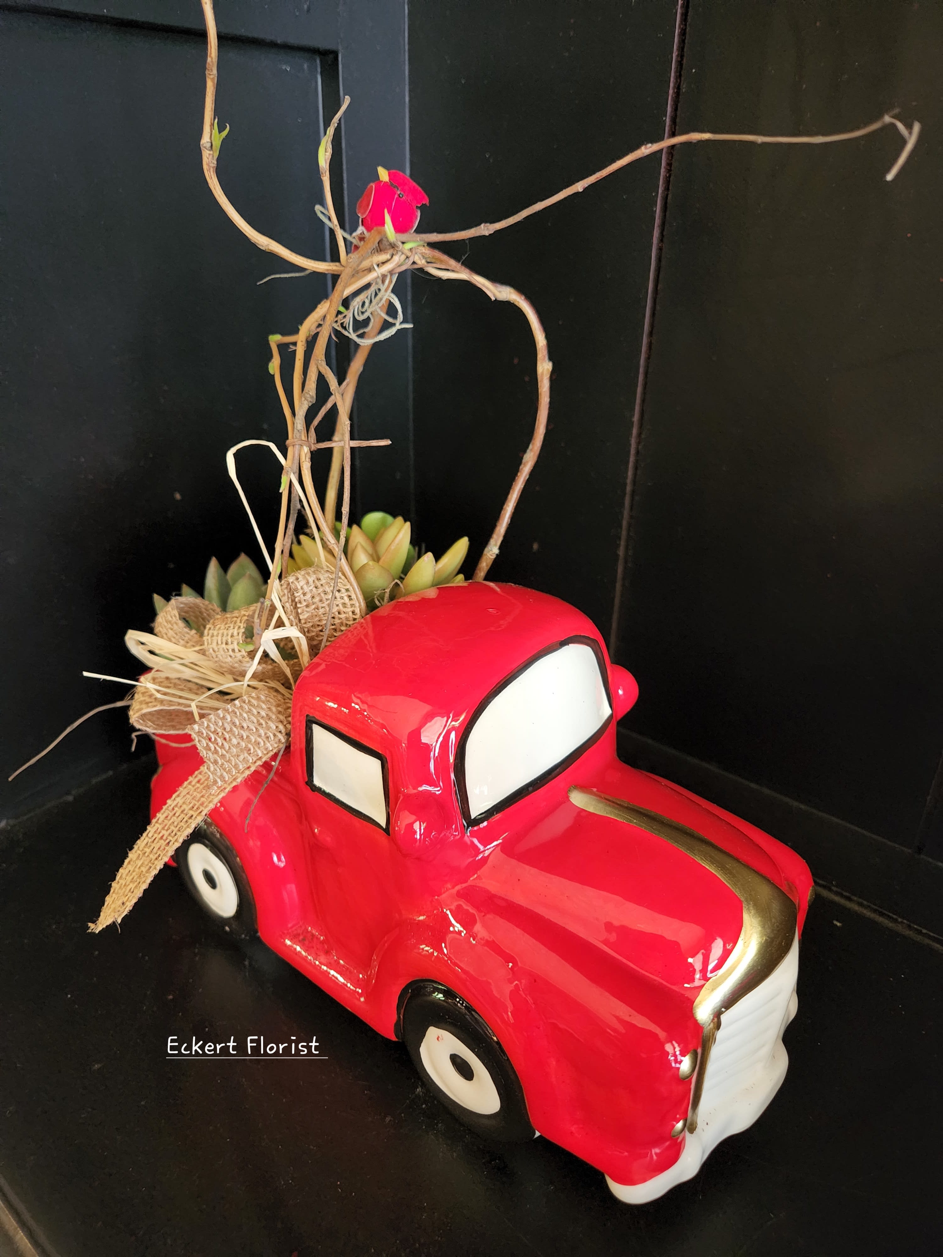 Red truck planter with succulents and a twig topper