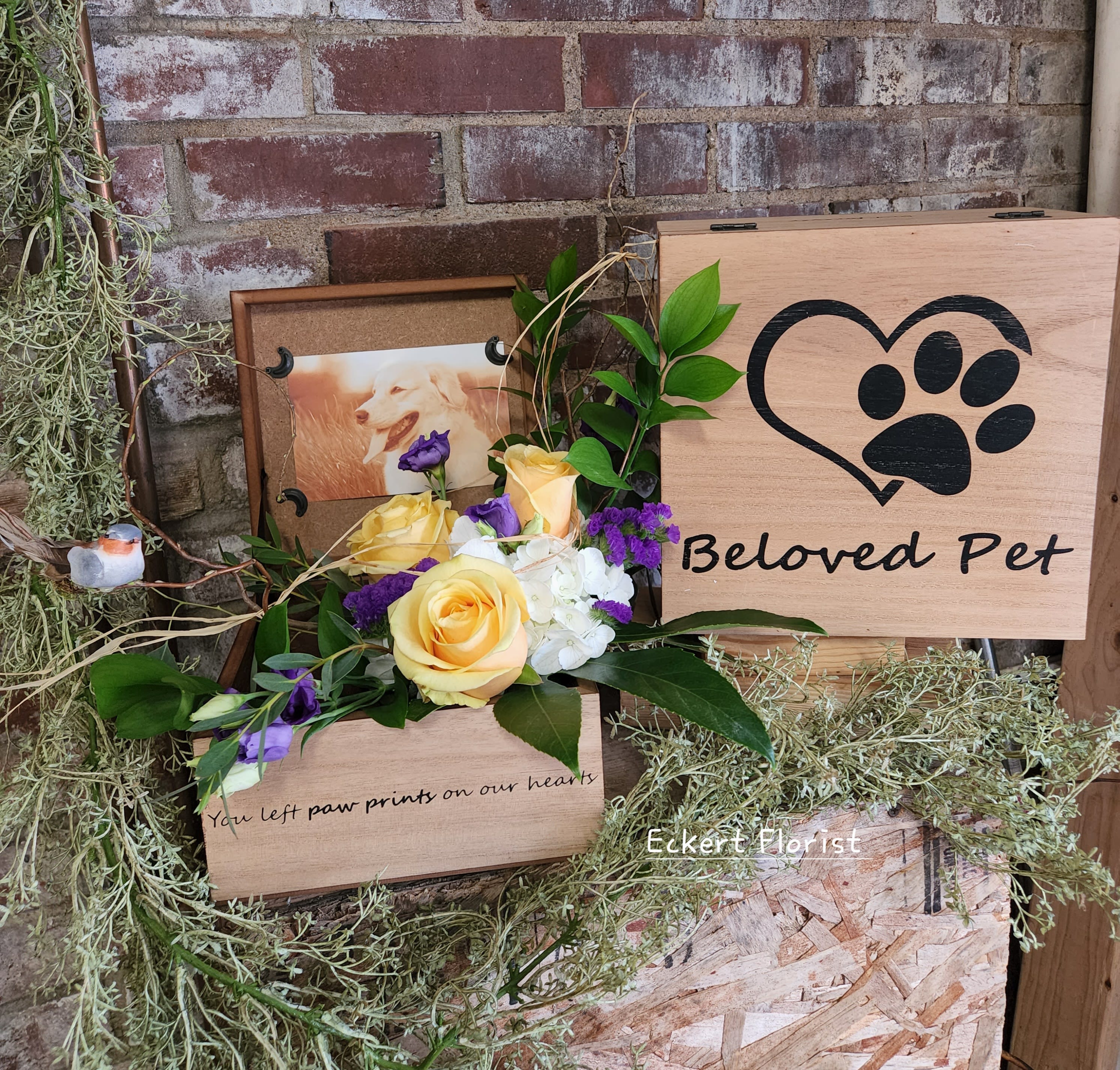 Yellow and purple rose arrangement beside a wooden pet memorial sign