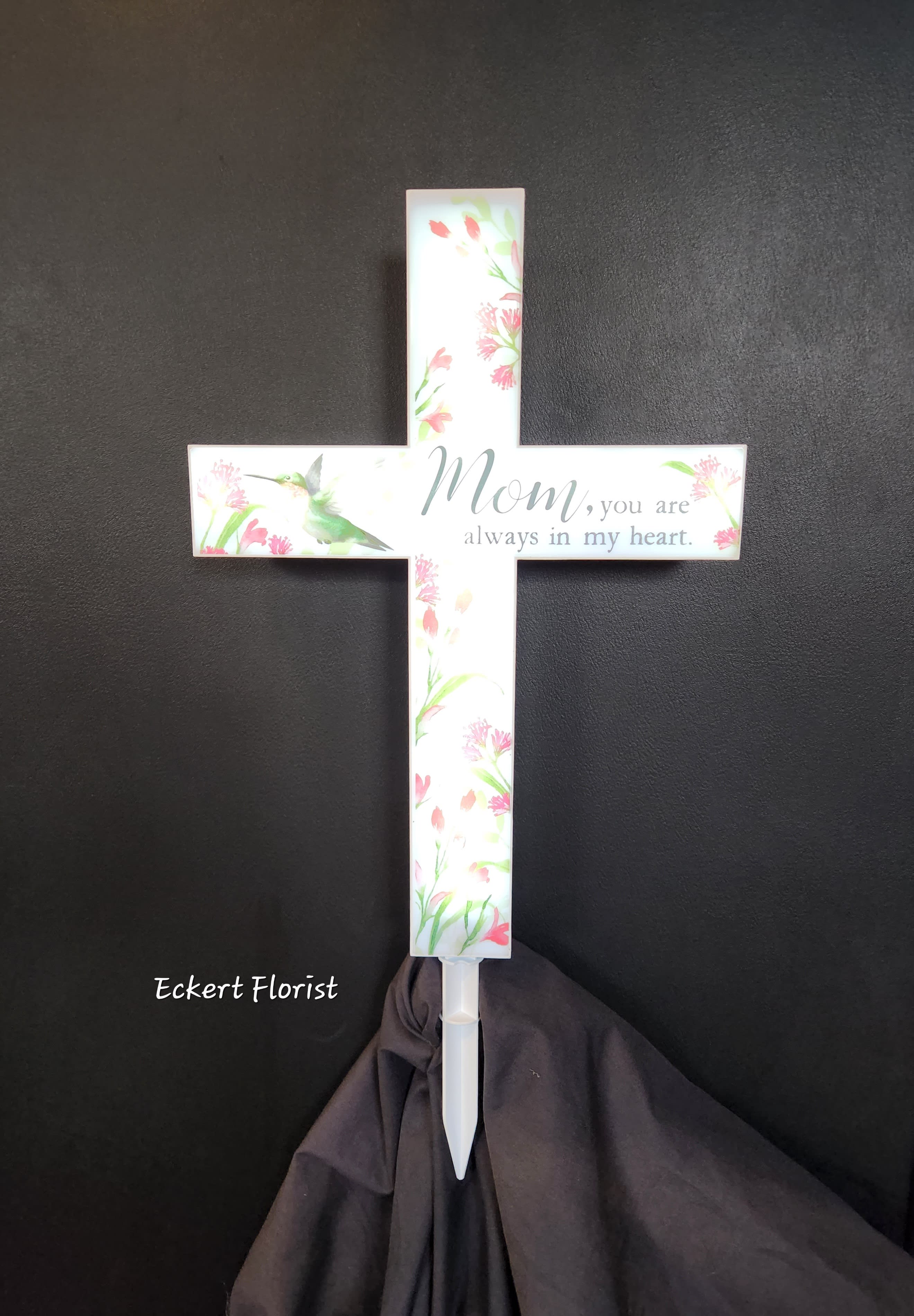 White memorial cross with floral print and the words "Mom, you are always in my heart."