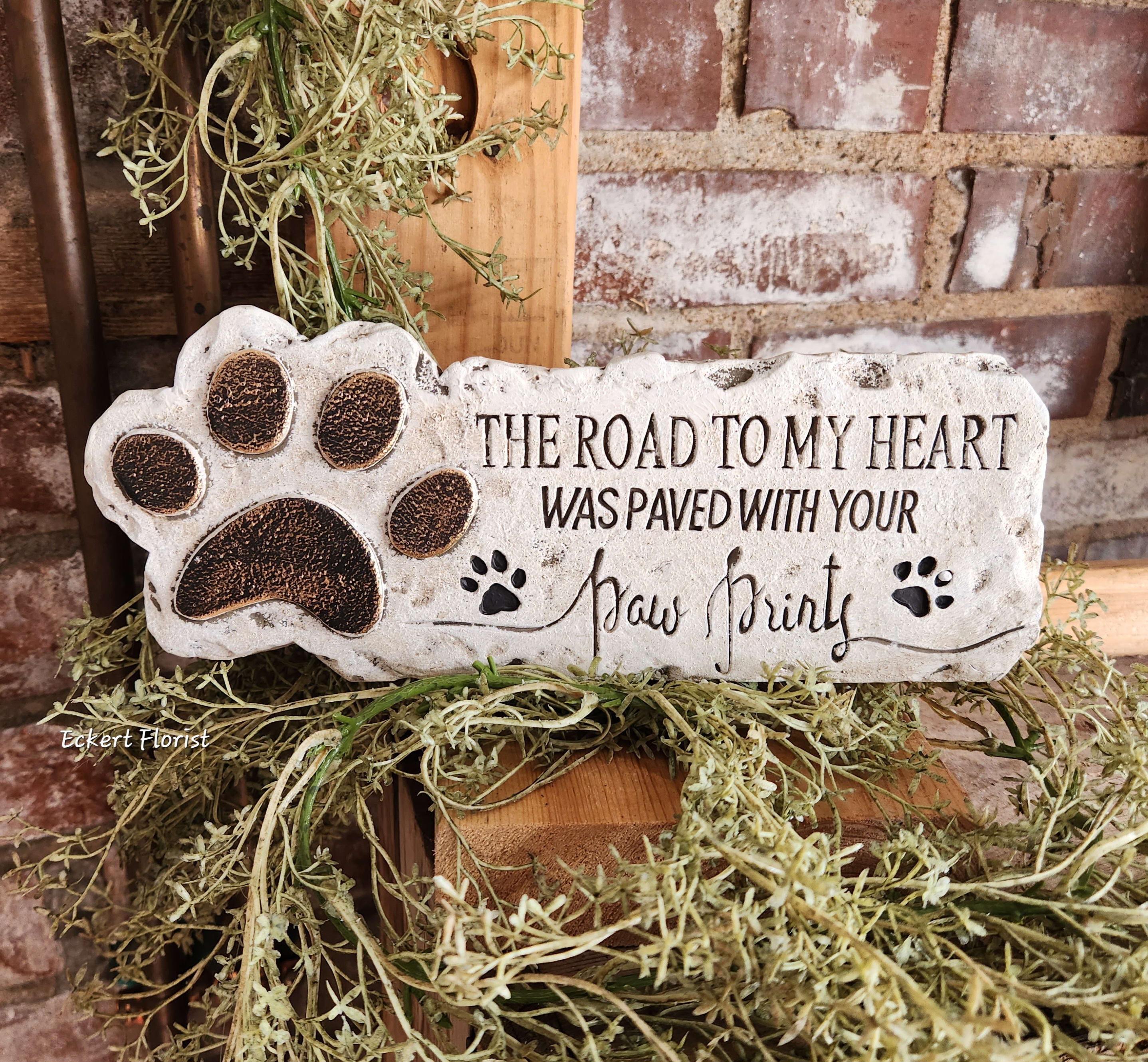 Decorative stone plaque with a paw print and memorial text