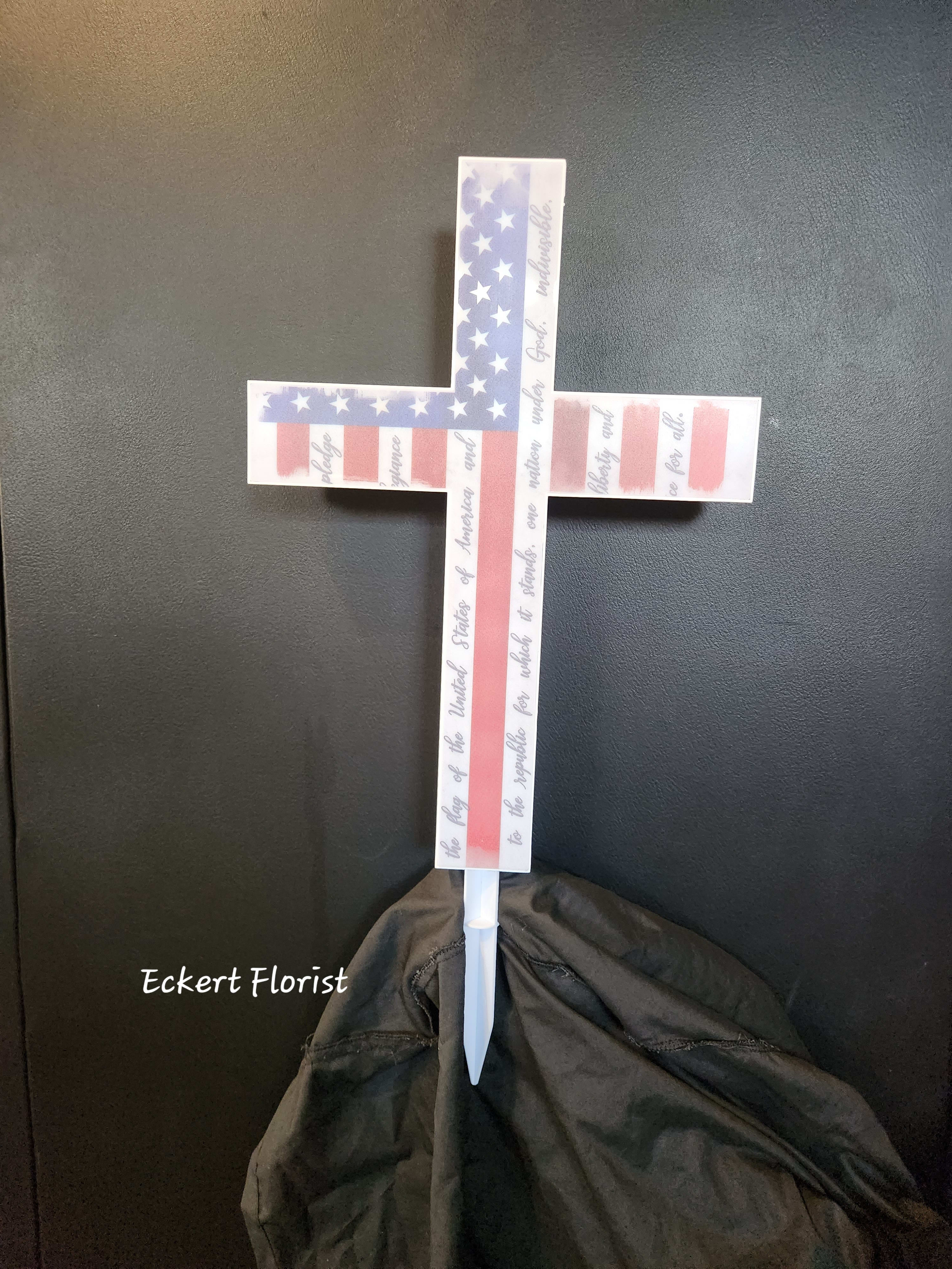 American flag cross-shaped memorial stake with a white base