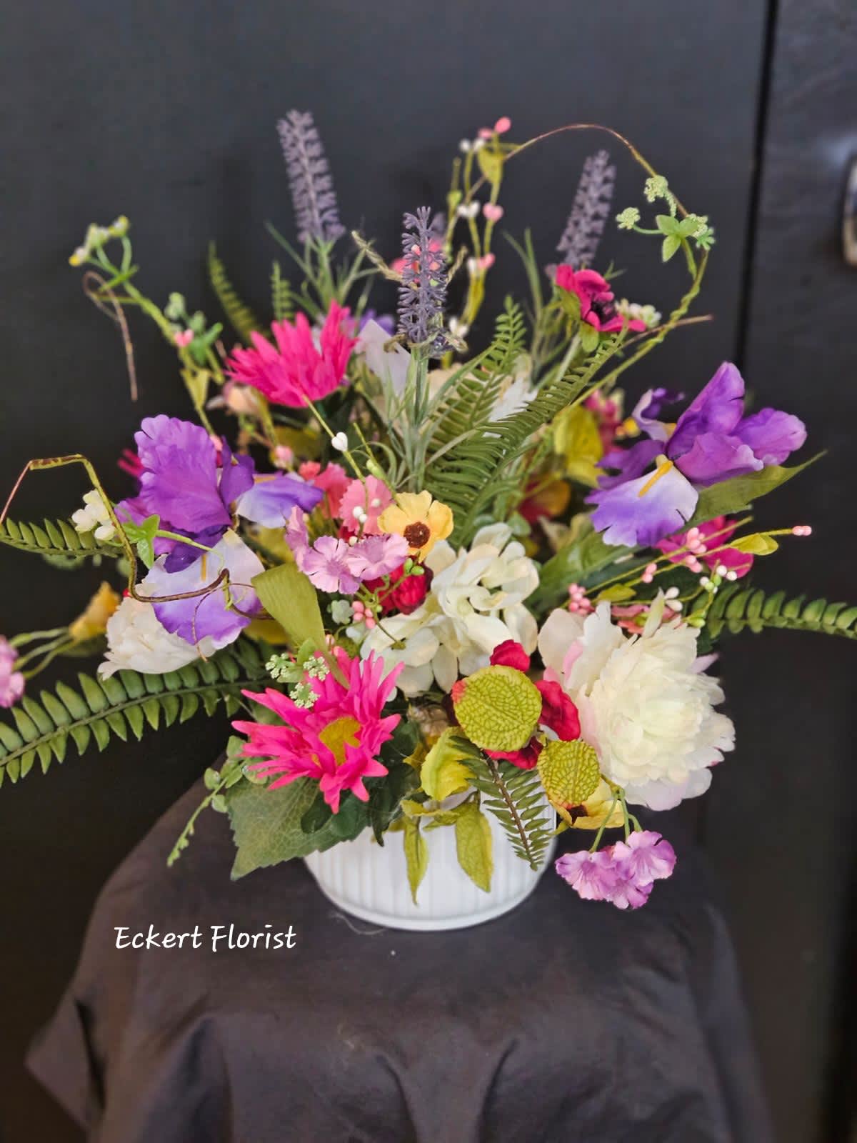 Colorful mixed bouquet in a white vase with purple, pink, and white blooms