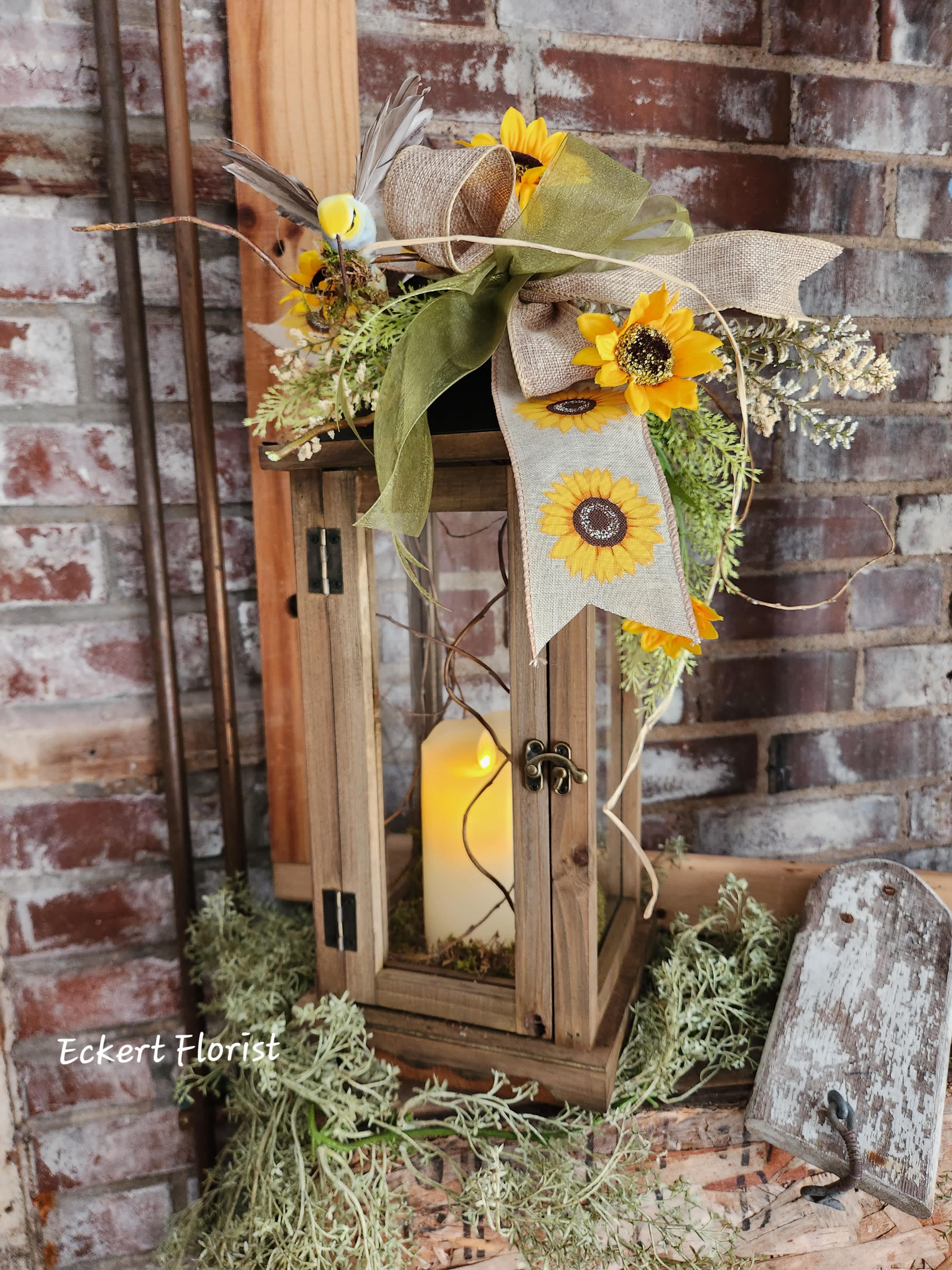 Sunflower arrangement on a wooden lantern with a candle inside