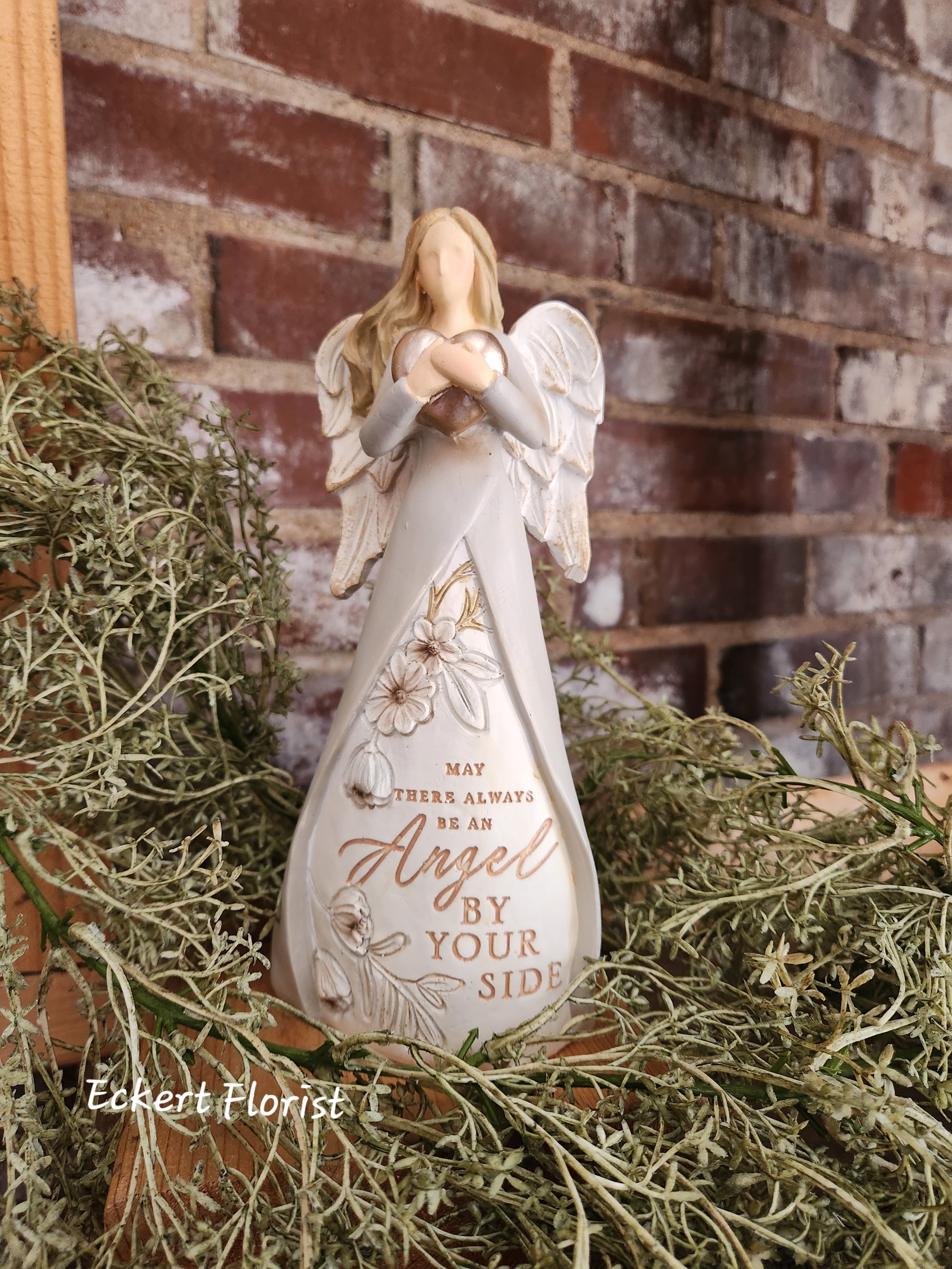 Angel figurine holding a heart with a memorial message