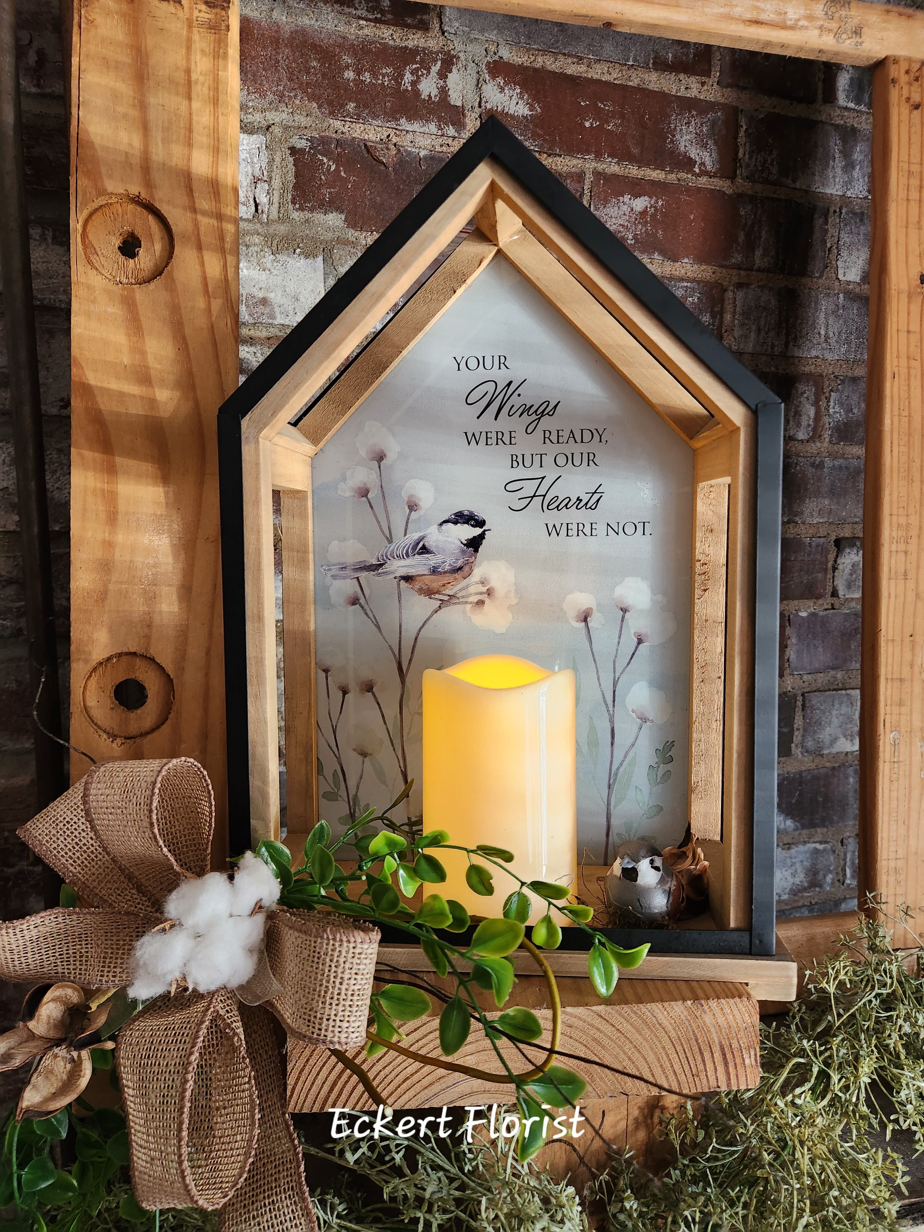 House-shaped memorial lantern with a bird print and glowing candle