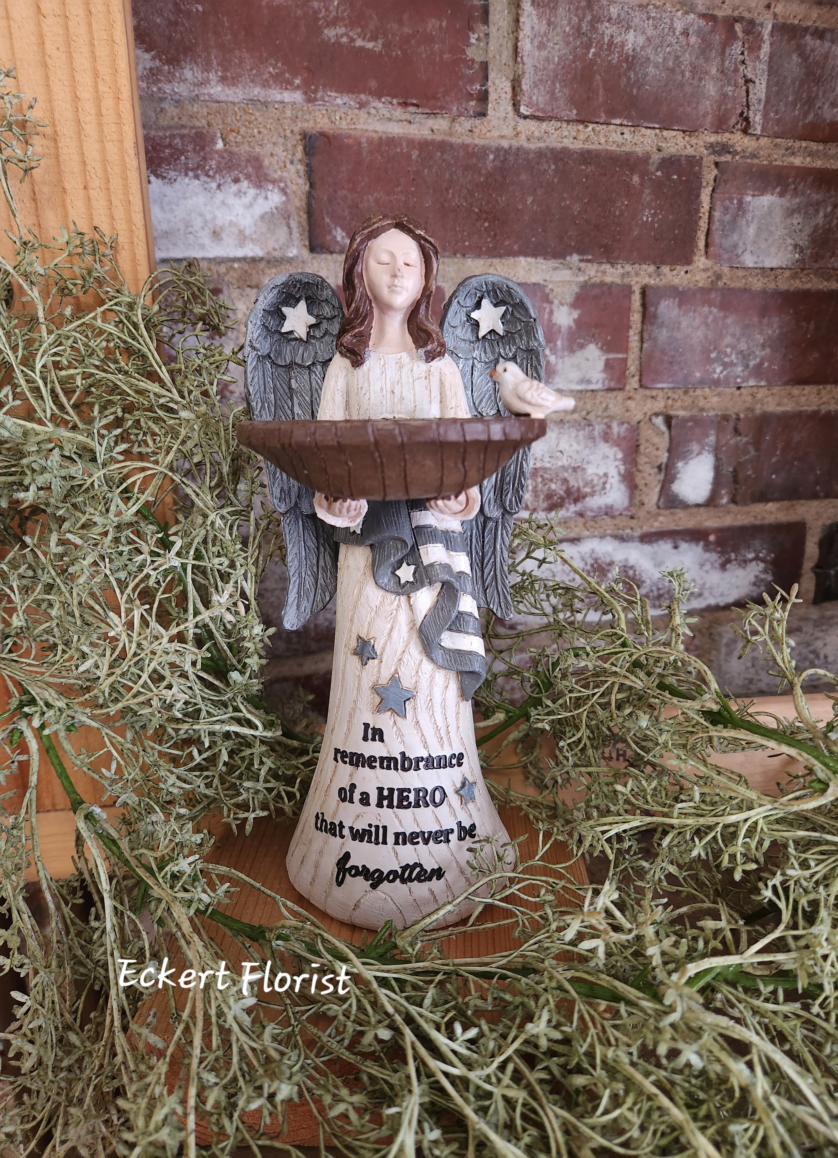 Angel memorial figurine holding a bowl with a small bird