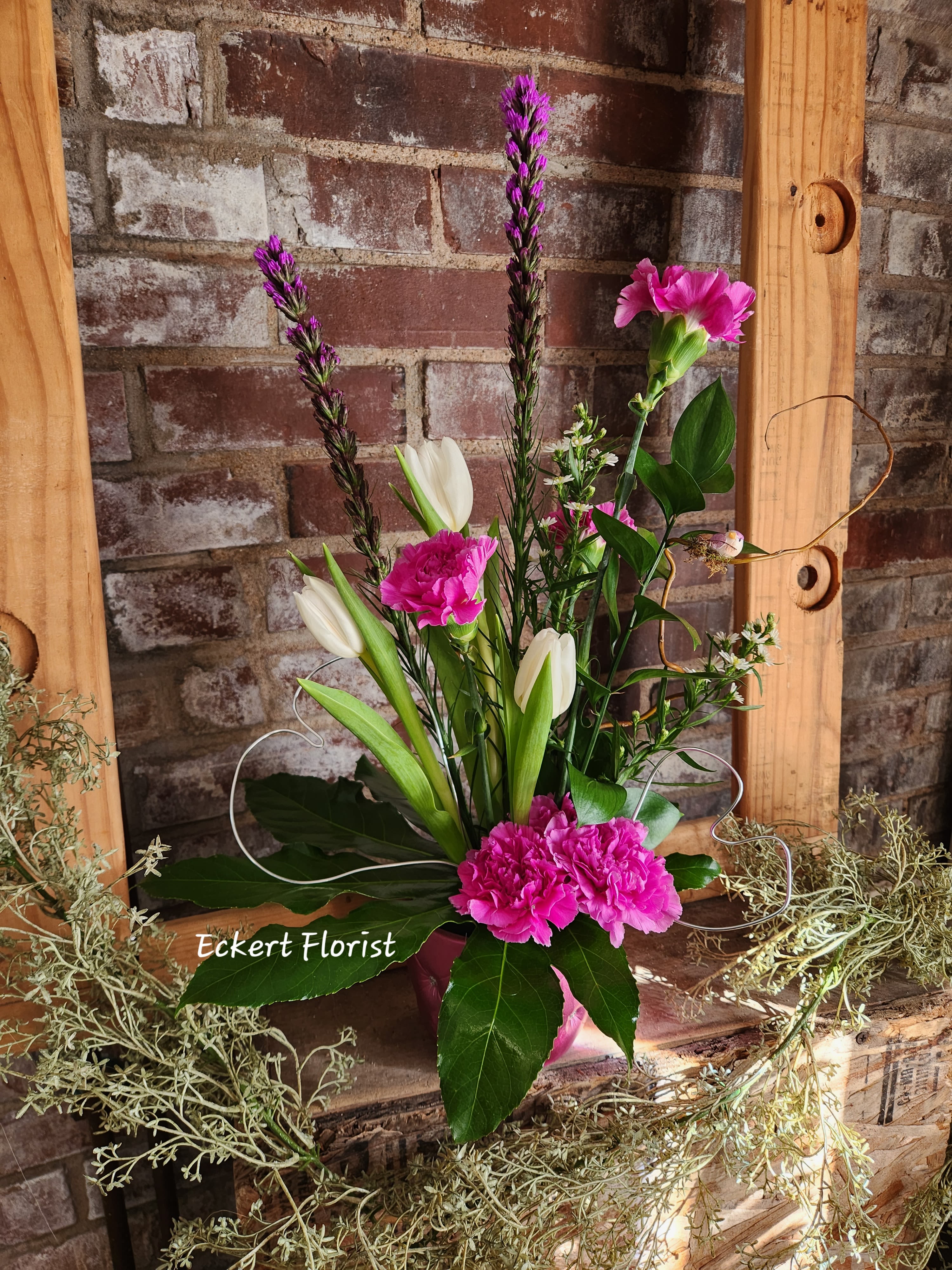 Pink and white floral arrangement with tulips and carnations in a vase