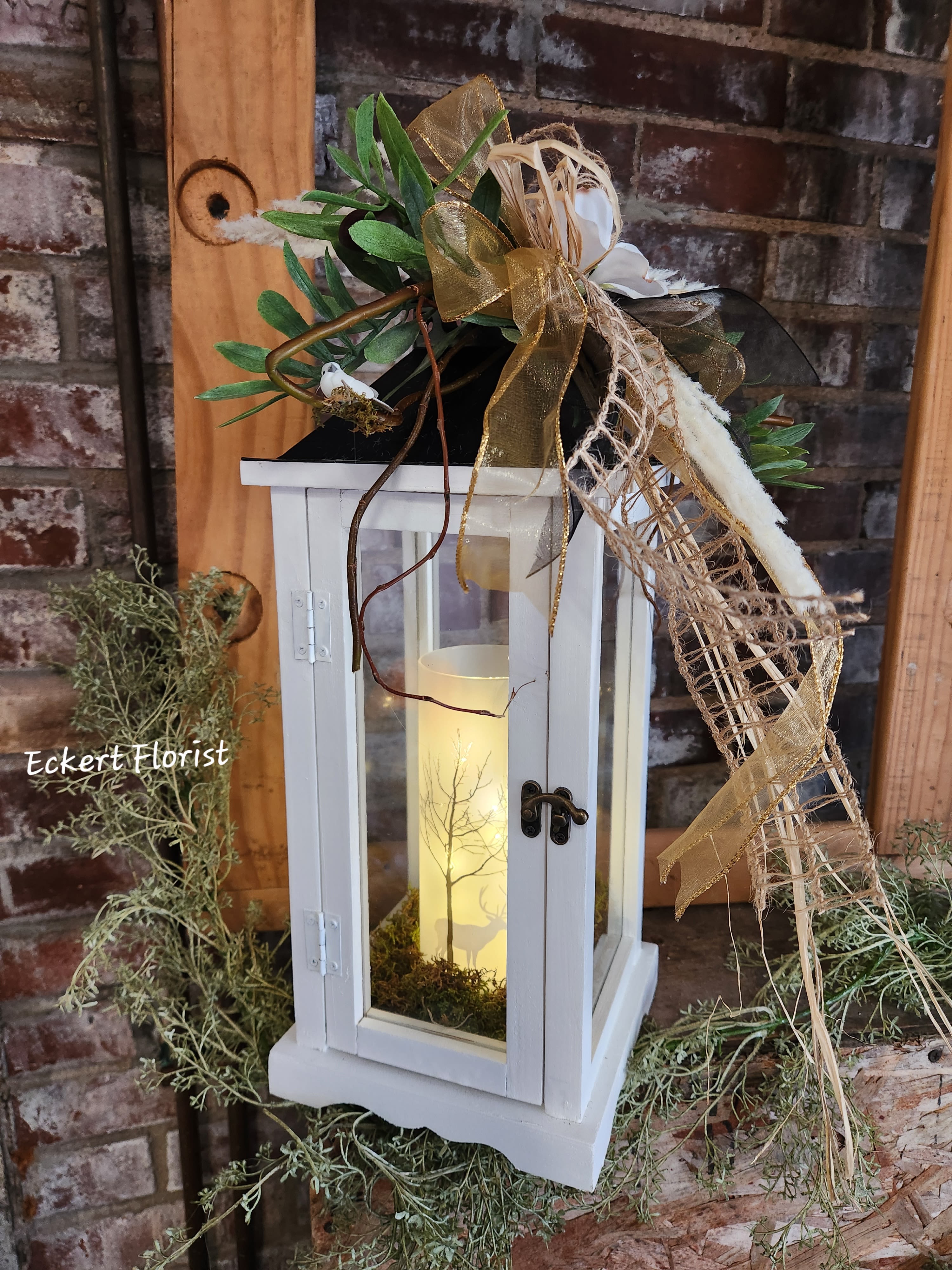 White lantern with candle and gold ribbon decoration