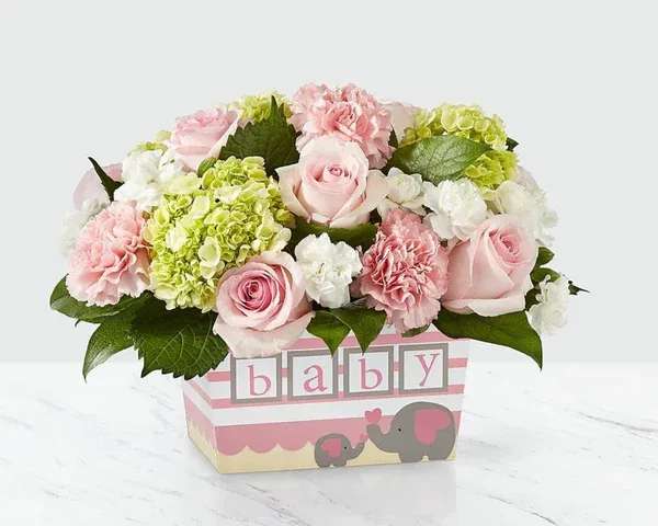 Pink roses and carnations in a baby-themed box