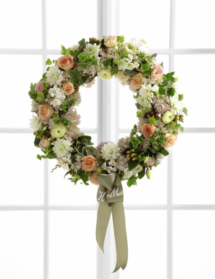 FTD Garden Splendor Wreath - The FTD Garden Splendor Wreath will bring a sweet grace to your  ceremony or celebration on your wedding day. Peach roses, white dahlias, pale pink hydrangea, white freesia, pale yellow ranunculus, pale pink  lisianthus, peach hypericum berries and an assortment of lush greens are arranged to form a gorgeous wreath accented with a light green satin  ribbon. Approx. 24-inches in diameter.